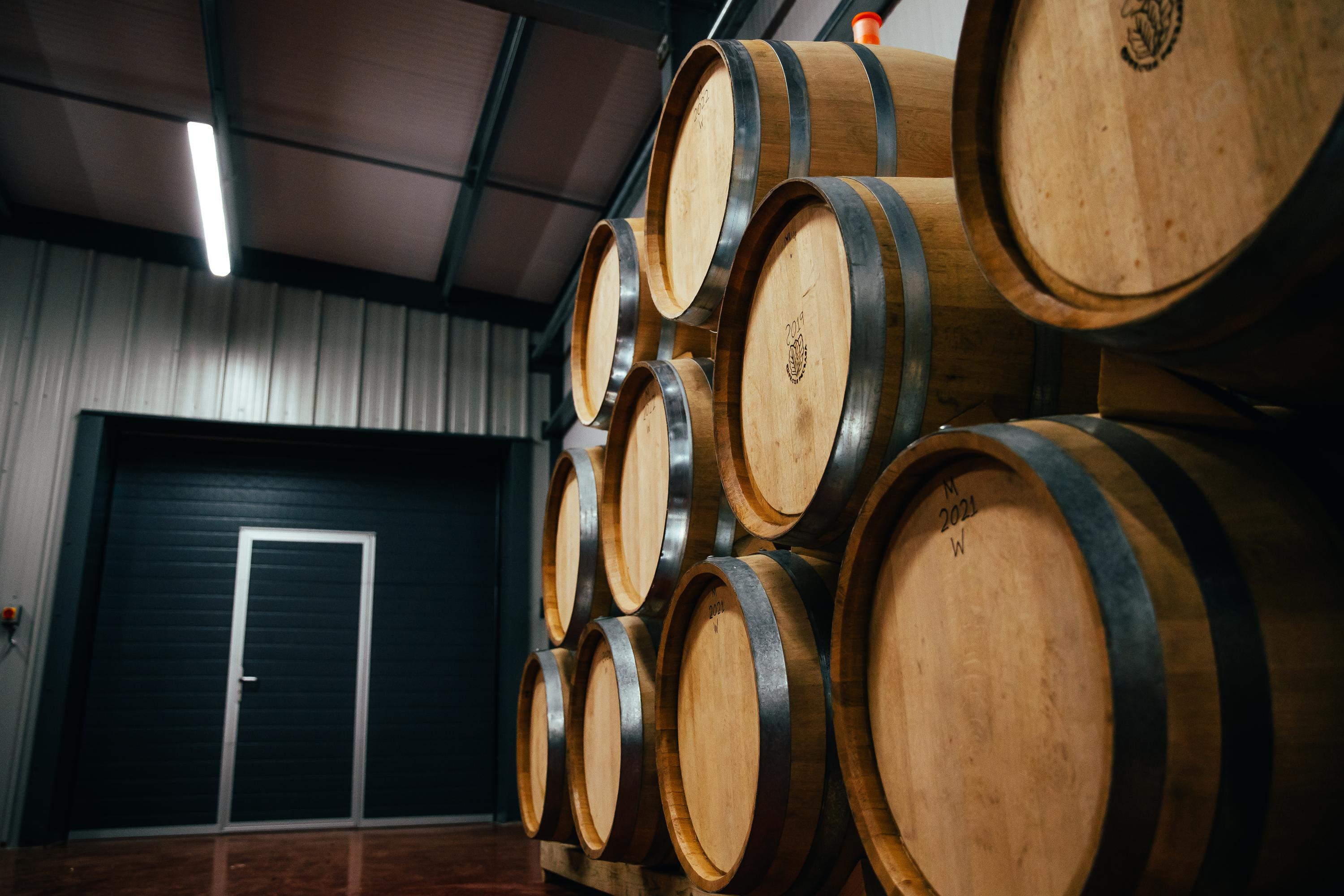 A close-up shot of some wine barrels in a warehouse.