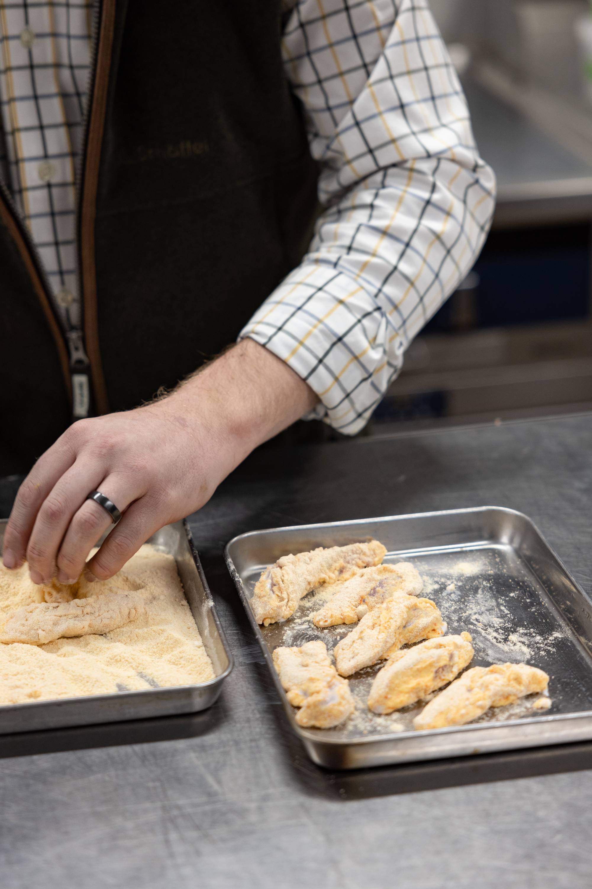 The pheasant goujons are dipped in the buttermilk and then the strips are rolled in the flour and seasoning mixture.