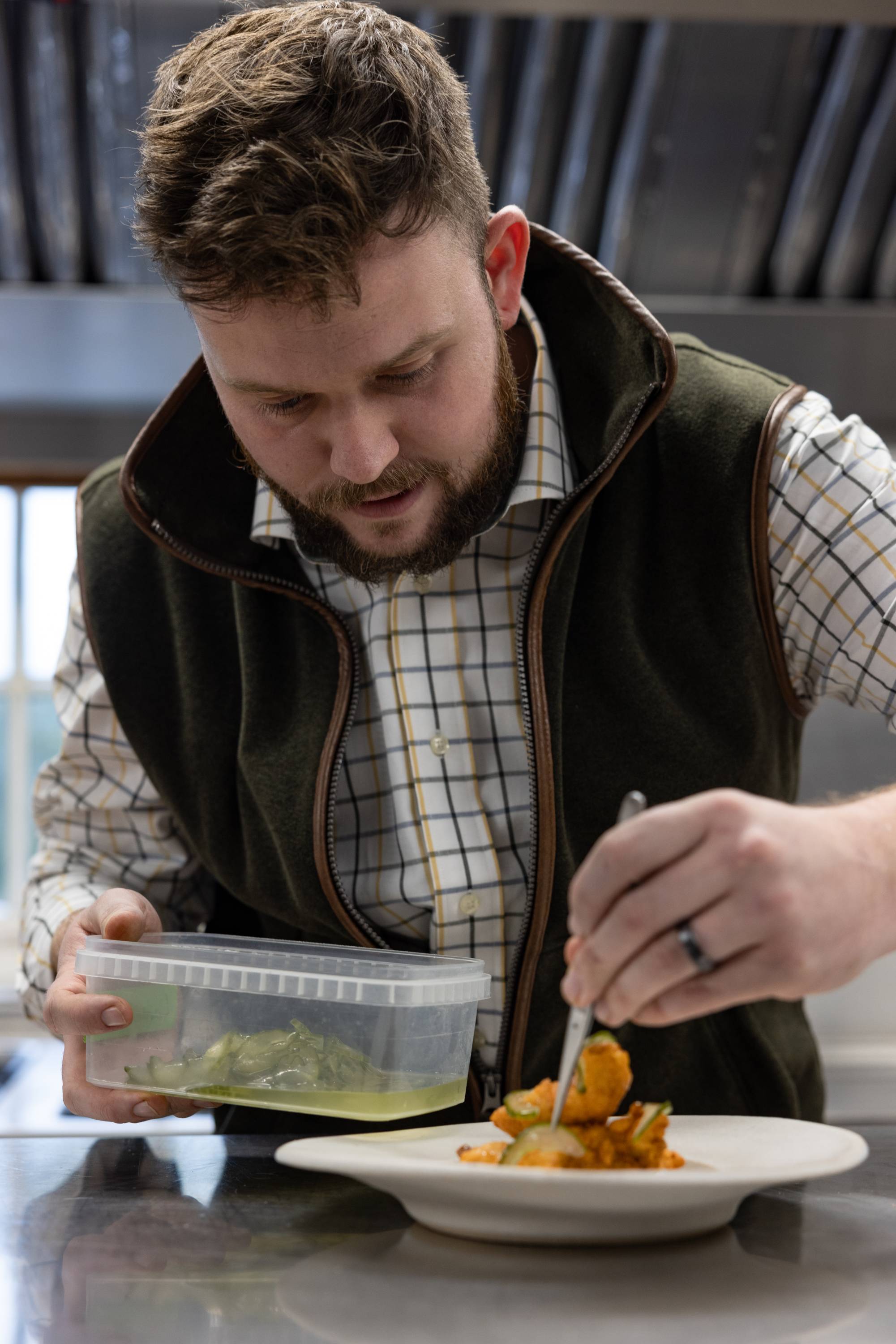 The finishing touches. Callum plates up the pheasant goujons and adds pickled cucumber slices before drizzling with yoghurt.