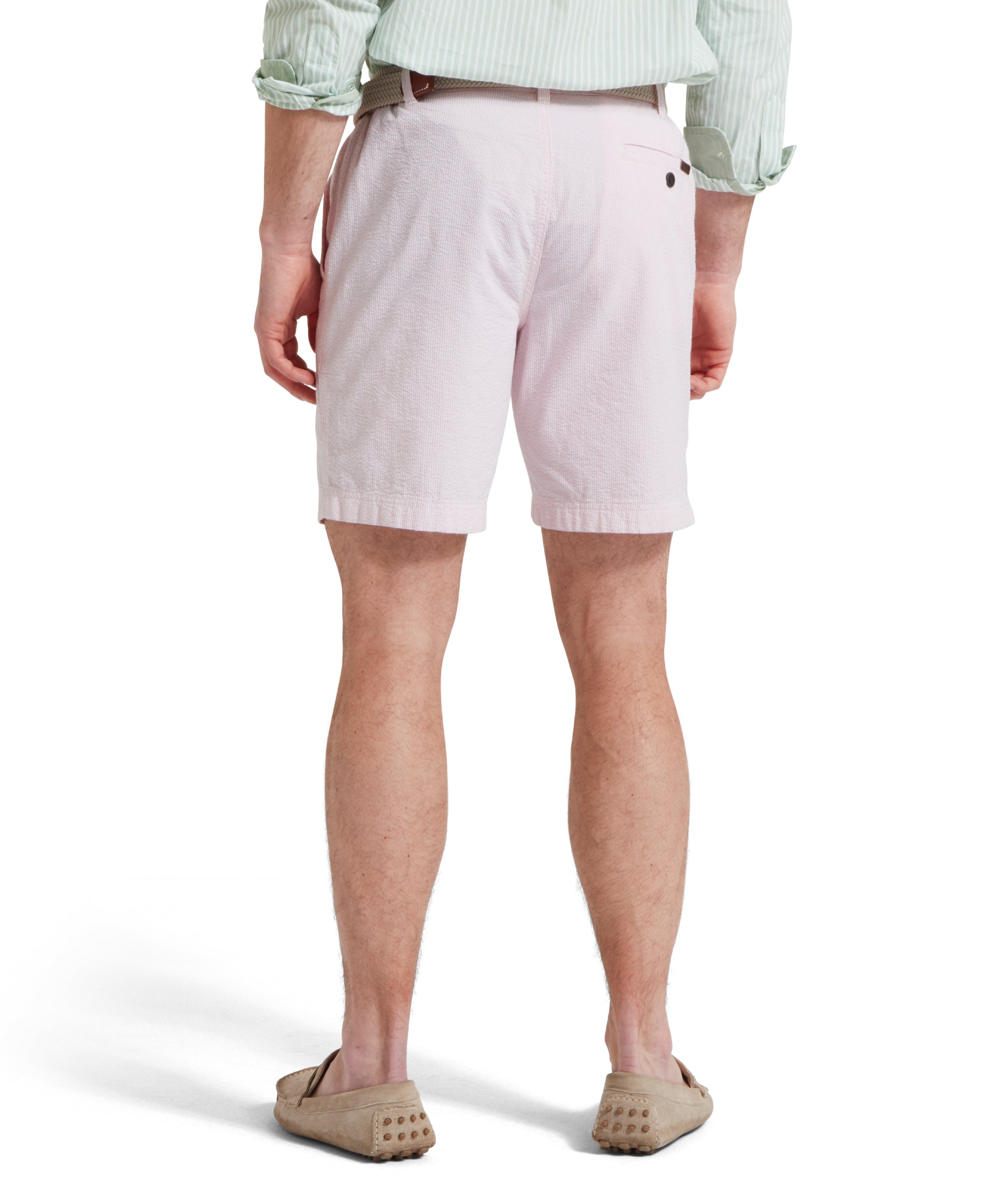 A back image of a male model wearing a light pink shorts with a tucked in light green and white striped shirt. It is paired with a beige woven belt and tan loafers. He is standing in a relaxed pose with his hands by his side.