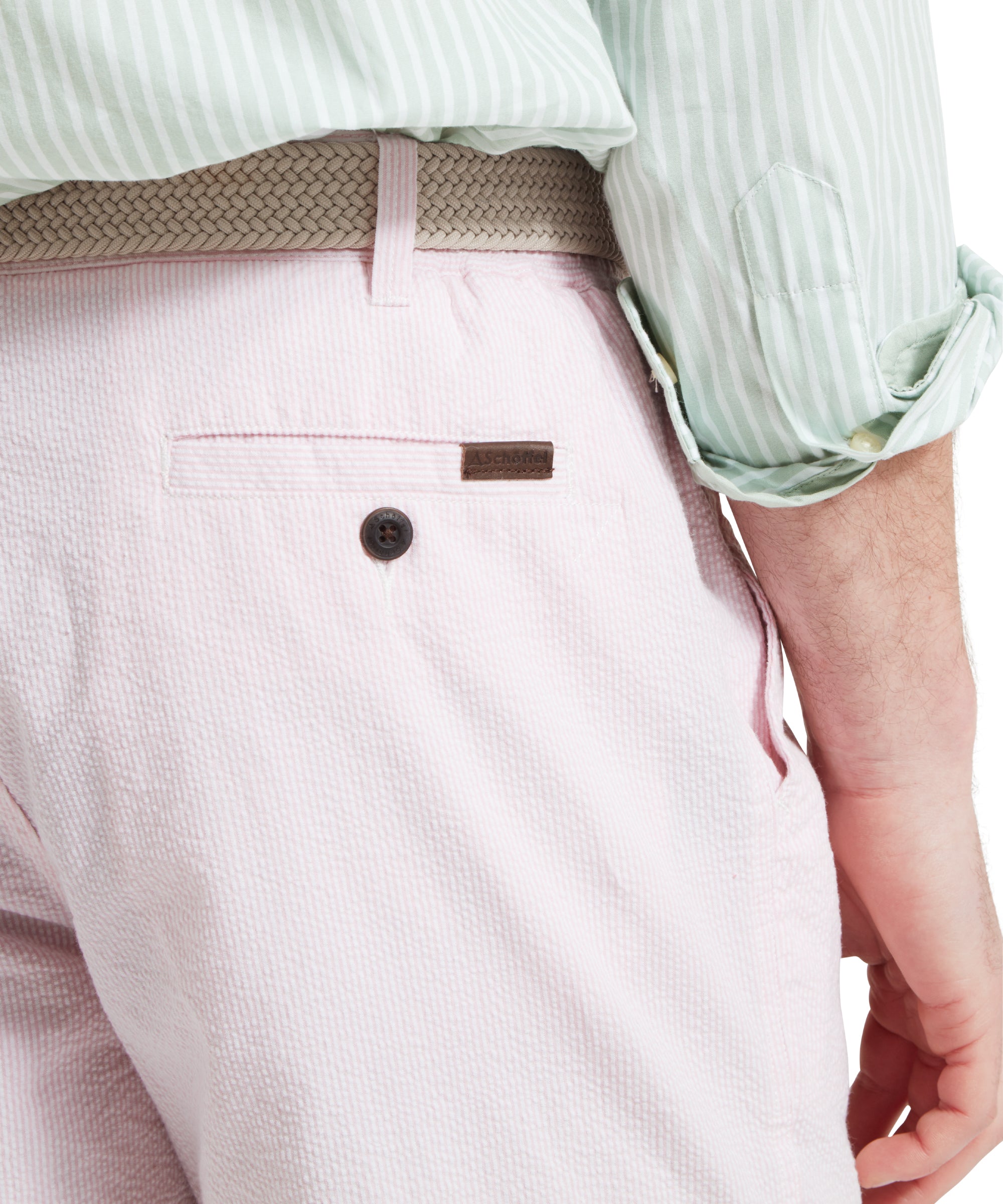 A close up image of a male model wearing a light pink shorts with a tucked in light green and white striped shirt. It is paired with a beige woven belt and tan loafers. The image highlights the belt loop and back pocket.