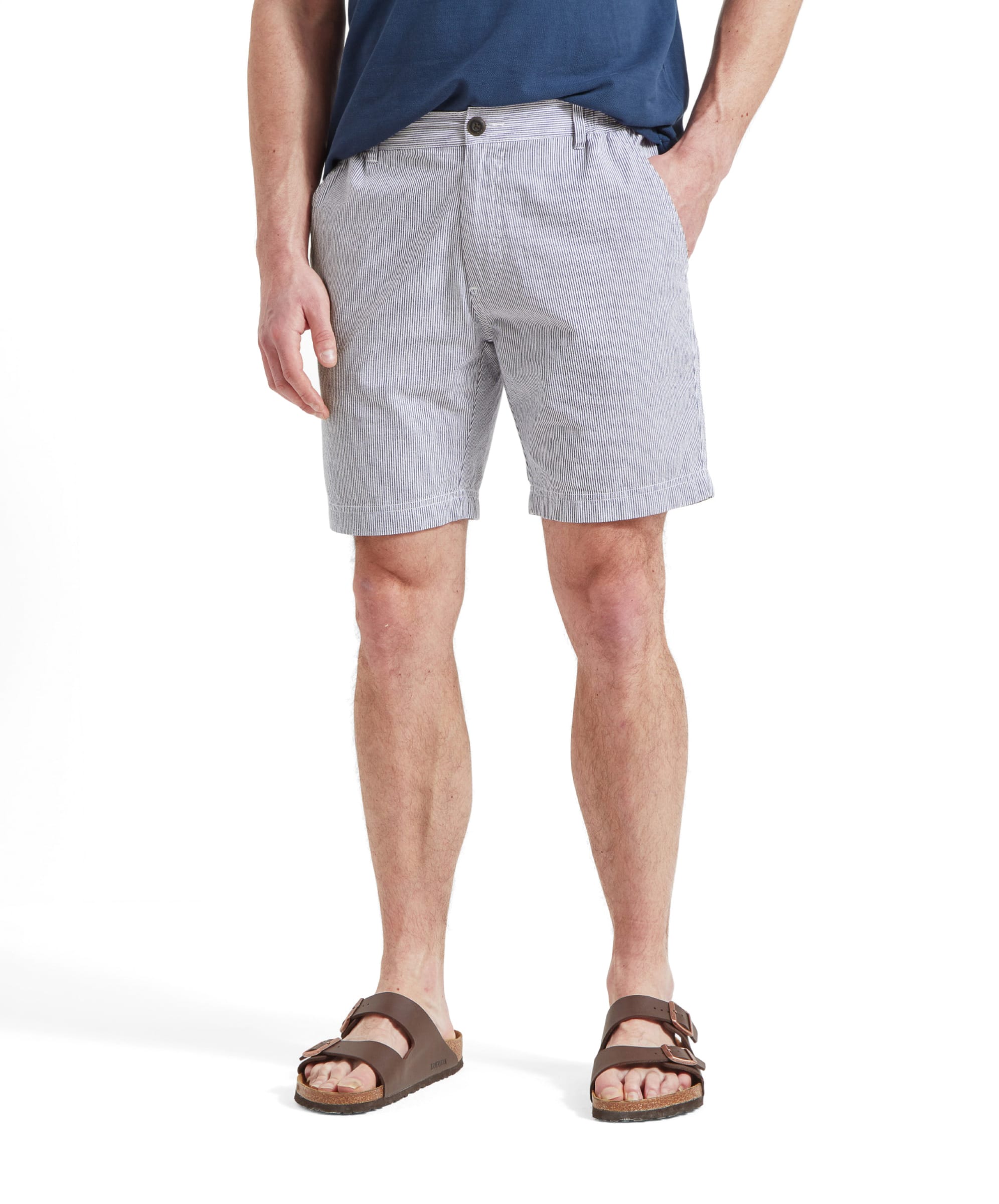 A close-up shot of a man wearing the Schöffel Abersoch Shorts for Men in Navy, showing the front view from the waist down. He is also wearing brown sandals.