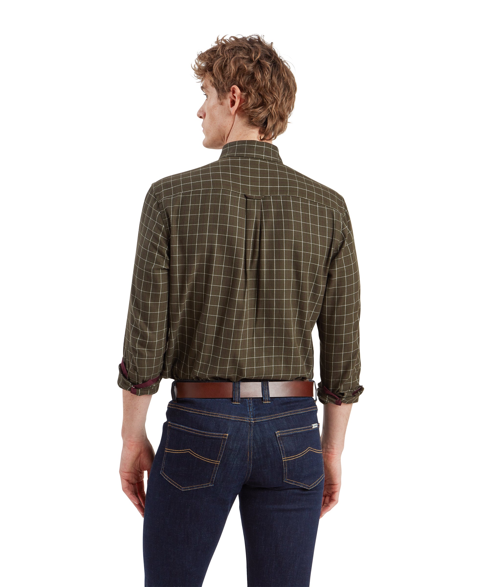 The man is turned with his back facing the camera, showcasing the back of the Schöffel Aldeburgh Tailored Shirt for Men in Green and dark blue jeans. The shirt has a relaxed fit with a slight tuck at the waist, and the jeans are well-fitted with visible stitching details.