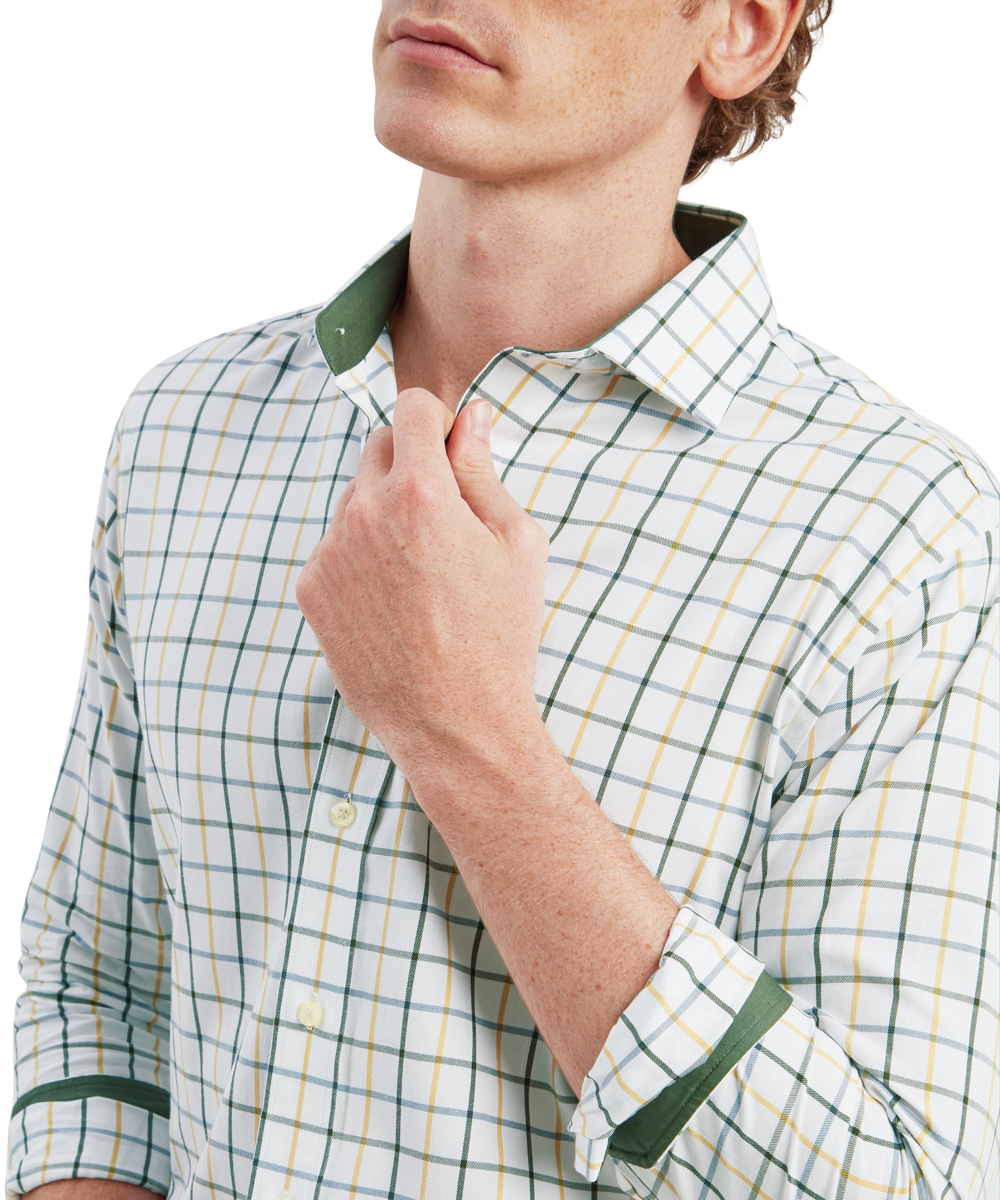 A close-up shot focusing on the upper half of the man's torso. He is adjusting the collar of his Schöffel Baconsthorpe Tailored Shirt for Men in Green with his right hand. The checkered pattern of the shirt, with its green, white, and yellow squares, is clearly visible. The inside of the collar is lined with a solid green fabric, adding a subtle contrast. The texture and fine detailing of the fabric are evident in this close-up view.