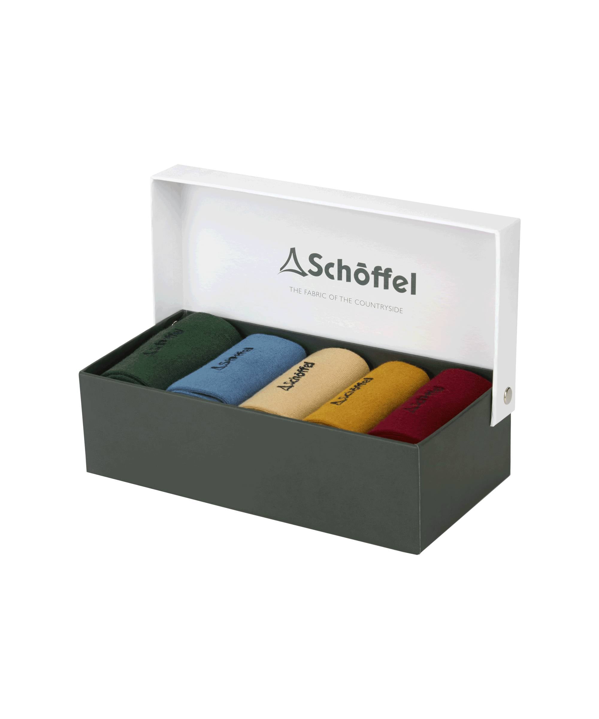 A dark green box with a white lid partially open, displaying the Schöffel Bamboo Sock Box of 5 for Men in Light Brown inside. The socks are in different solid colors: dark green, light blue, beige, mustard yellow, and burgundy, each with the "Schöffel" logo embroidered in black. The inside of the lid features the "Schöffel" logo and the tagline "The Fabric of the Countryside."