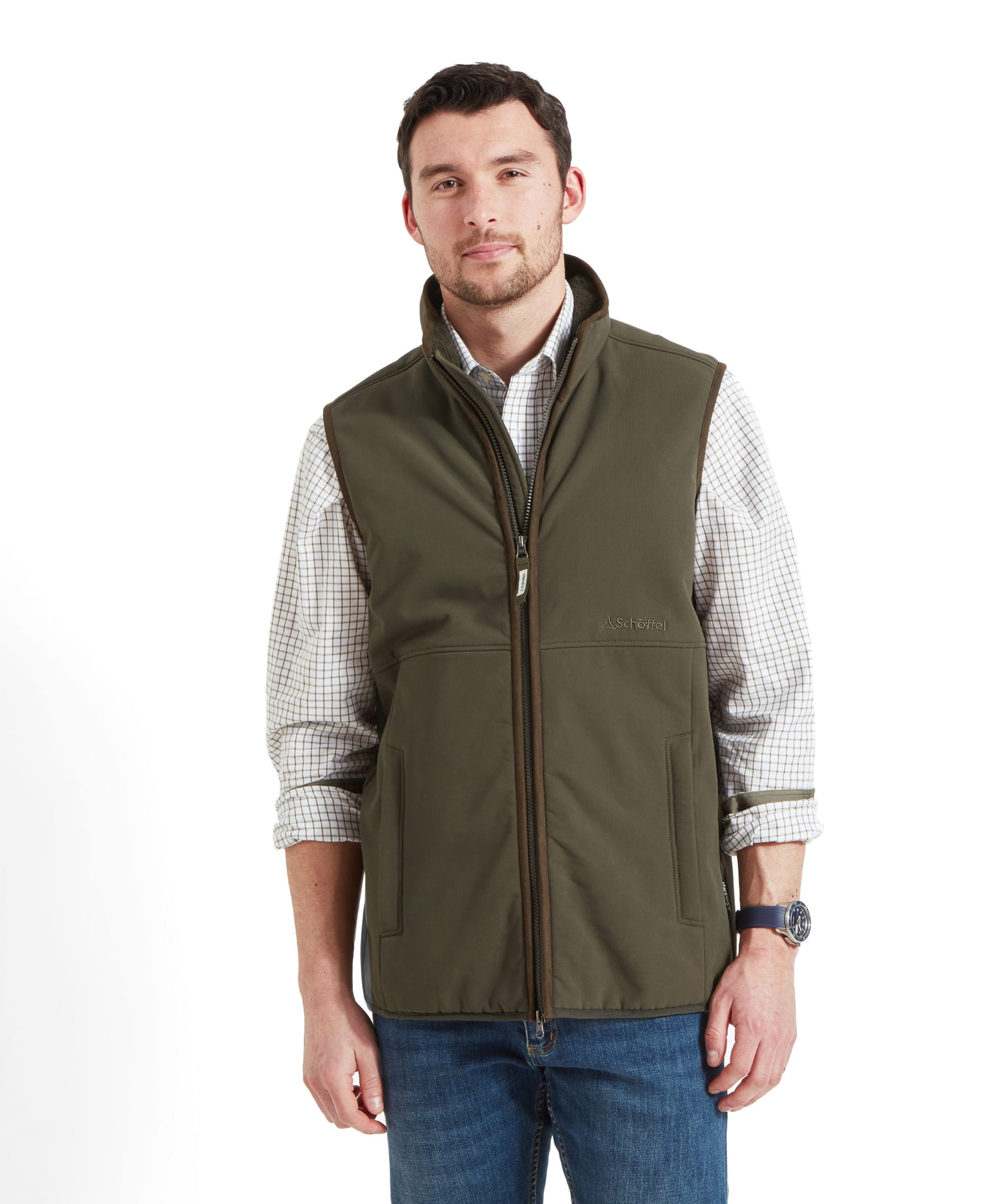 A man wearing a Schöffel Belton Gilet for Men in Green over a checkered shirt, posing with a slight smile.