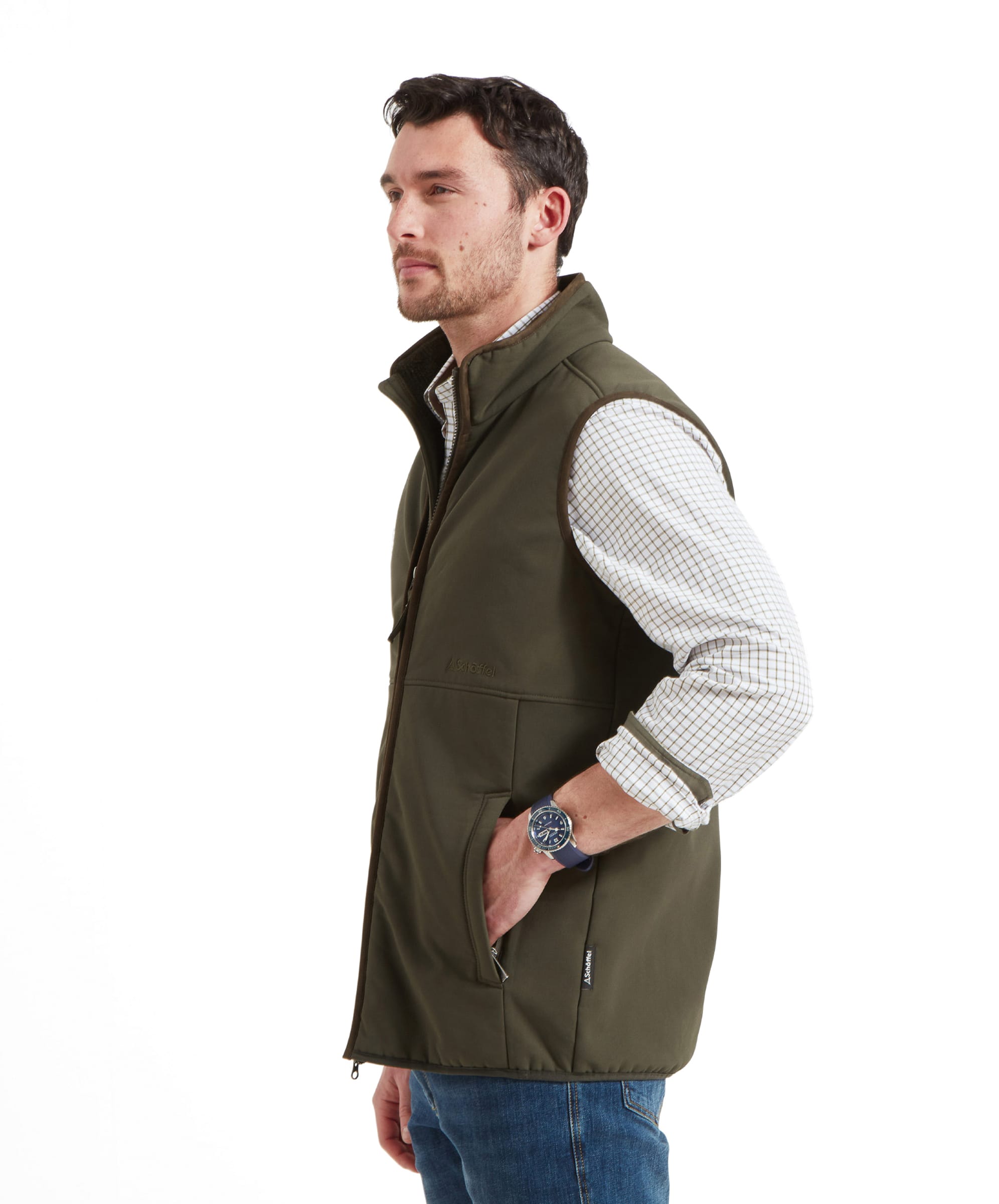 A side profile of the man in a Schöffel Belton Gilet for Men in Green, with his hands in his pockets.