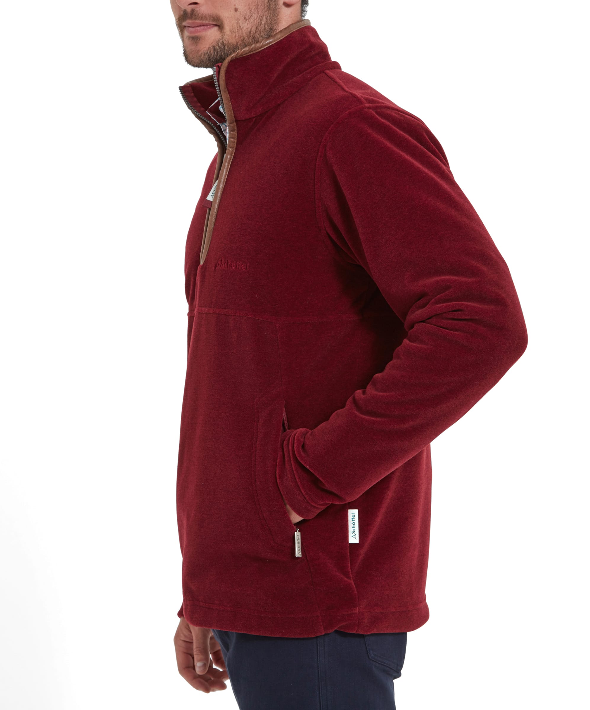 Side view of the man in the Schöffel Berkeley Fleece 1/4 Zip Fleece for Men in Red, showing the fleece’s zippered pocket and logo detail.