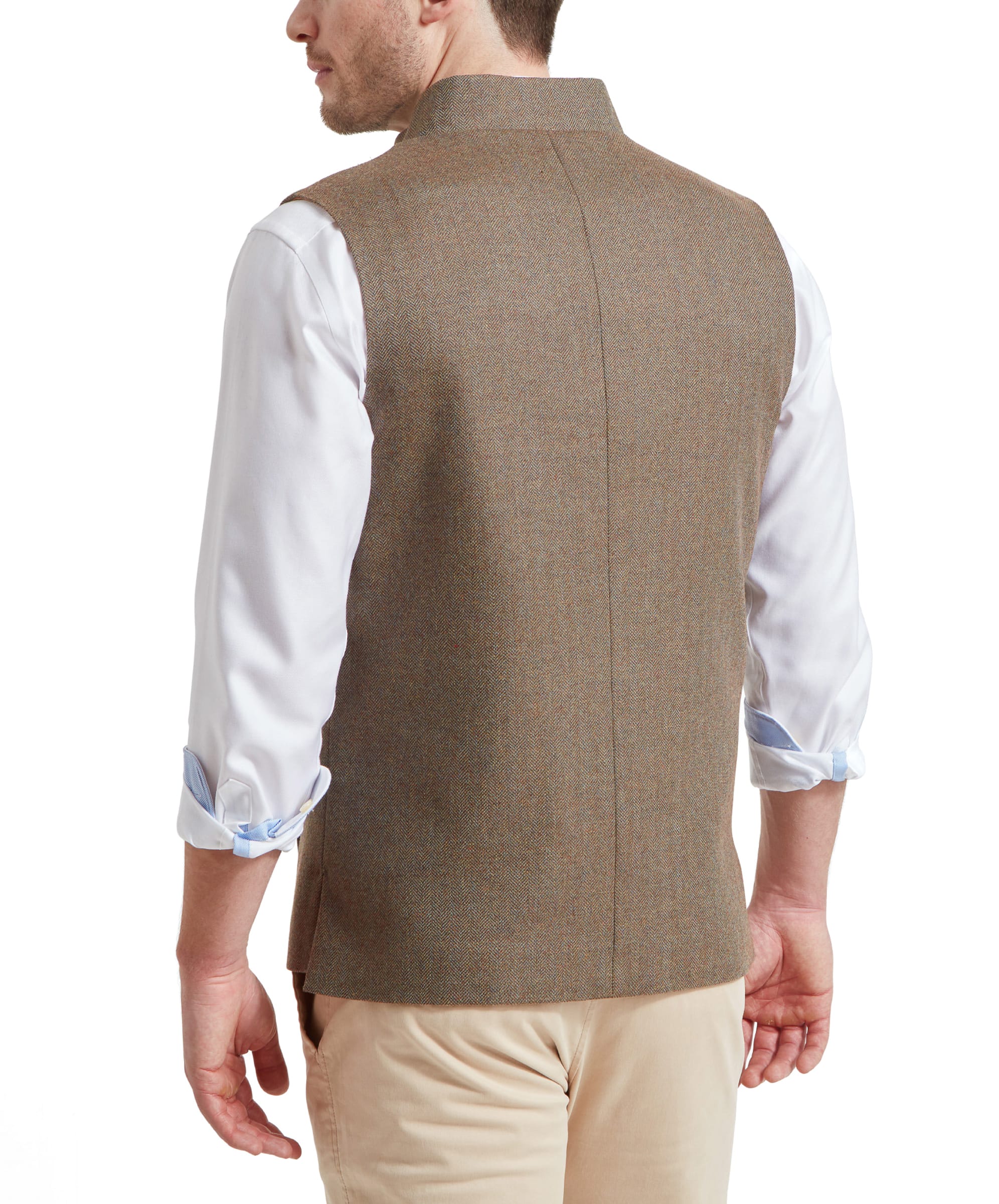 A man showing the back of a Schöffel Berwick Nehru Tweed Waistcoat for Men in Green over a white shirt with rolled-up sleeves, standing with his back to the camera.