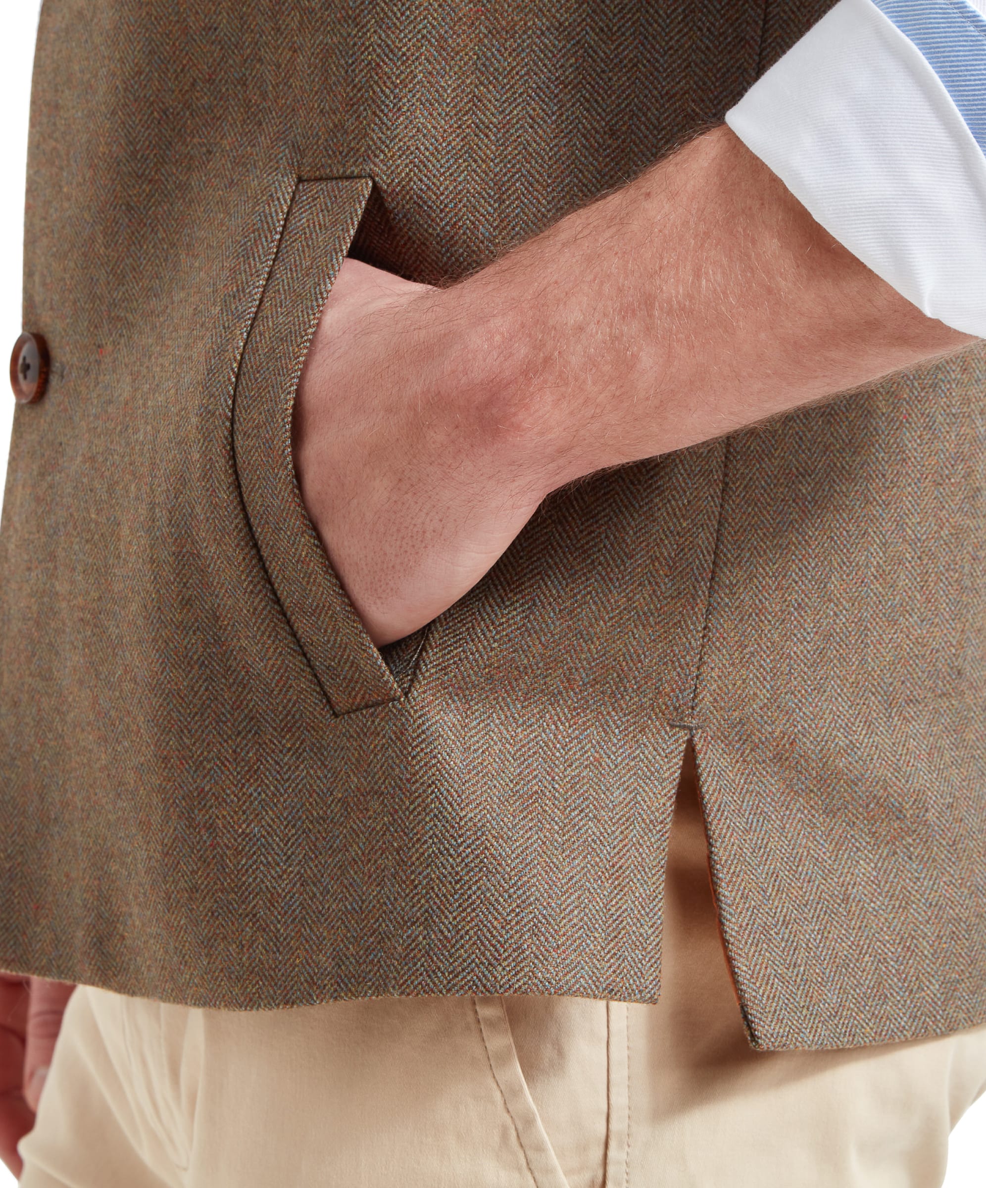 A close-up of a man's hand in the pocket of the Schöffel Berwick Nehru Tweed Waistcoat for Men in Green, highlighting the pocket detail and the fabric's texture.