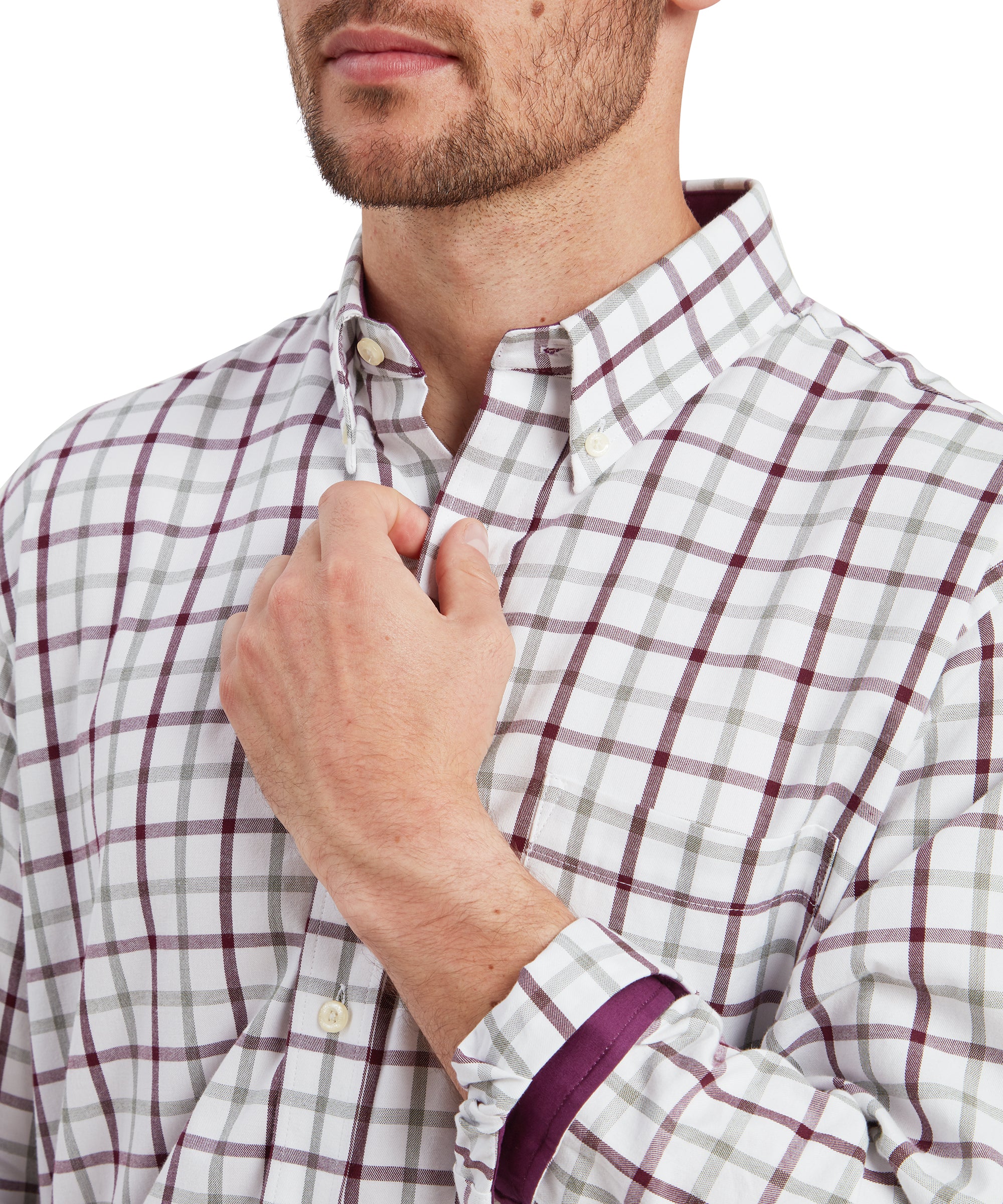 A close-up shot of the man’s upper chest, focusing on the Schöffel Brancaster Classic Shirt for Men in Red's pattern, collar, and button detailing. The maroon and gray check pattern is prominent, and the buttoned-down collar is crisp and neat. The man is lightly grasping the collar, showing the fabric’s texture and structure up close.