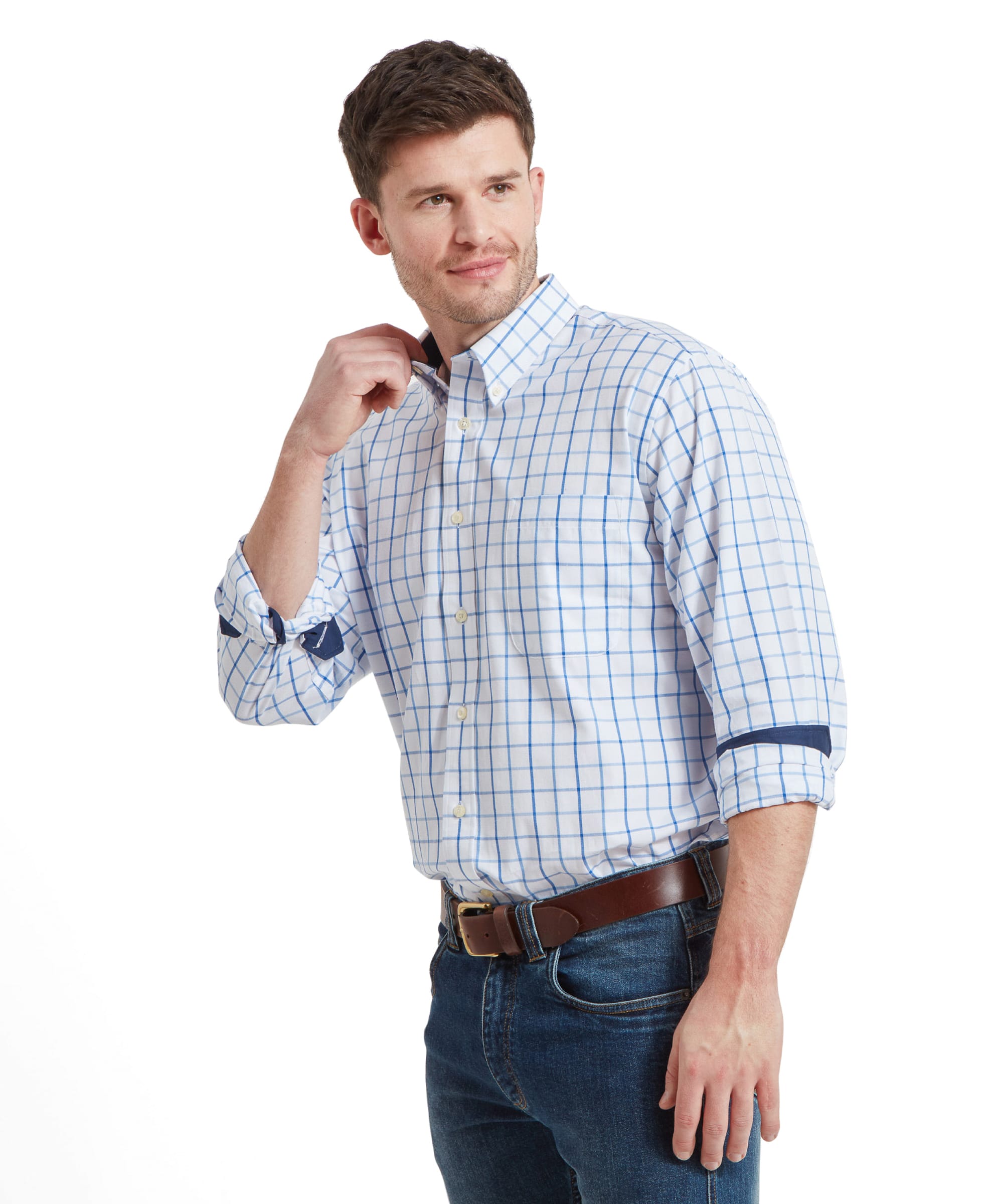 A closer shot of the man adjusting his collar while wearing the Schöffel Brancaster Classic Shirt for Men in Blue and jeans. He has a slight smile and is looking to his left.