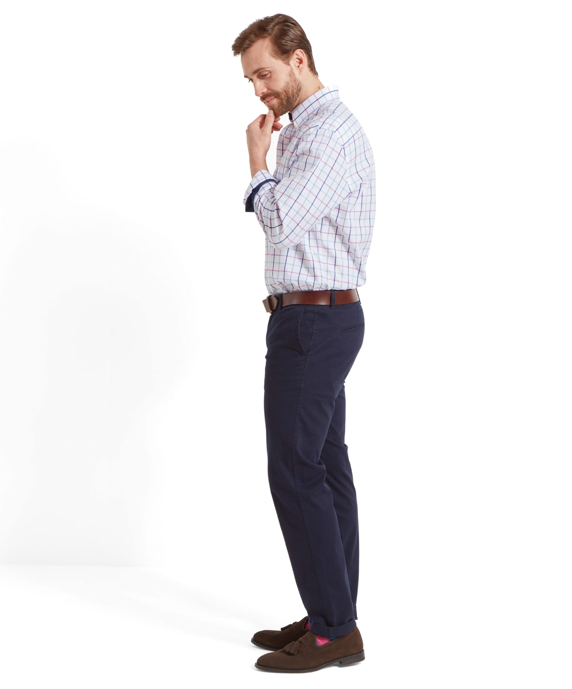 A side view of a man wearing the Schöffel Brancaster Classic Shirt for Men in Pink, showing the shirt's fit and the check pattern, while he looks down with his hand on his chin.