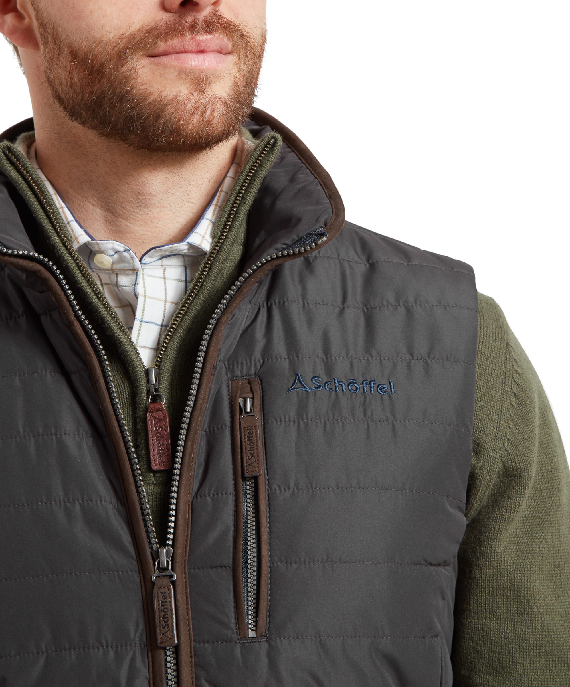 A detailed view of the Schöffel Brora Gilet for Men in Grey's chest pocket, featuring the Schöffel logo and zippered closure, emphasizing the gilet's practicality and style.