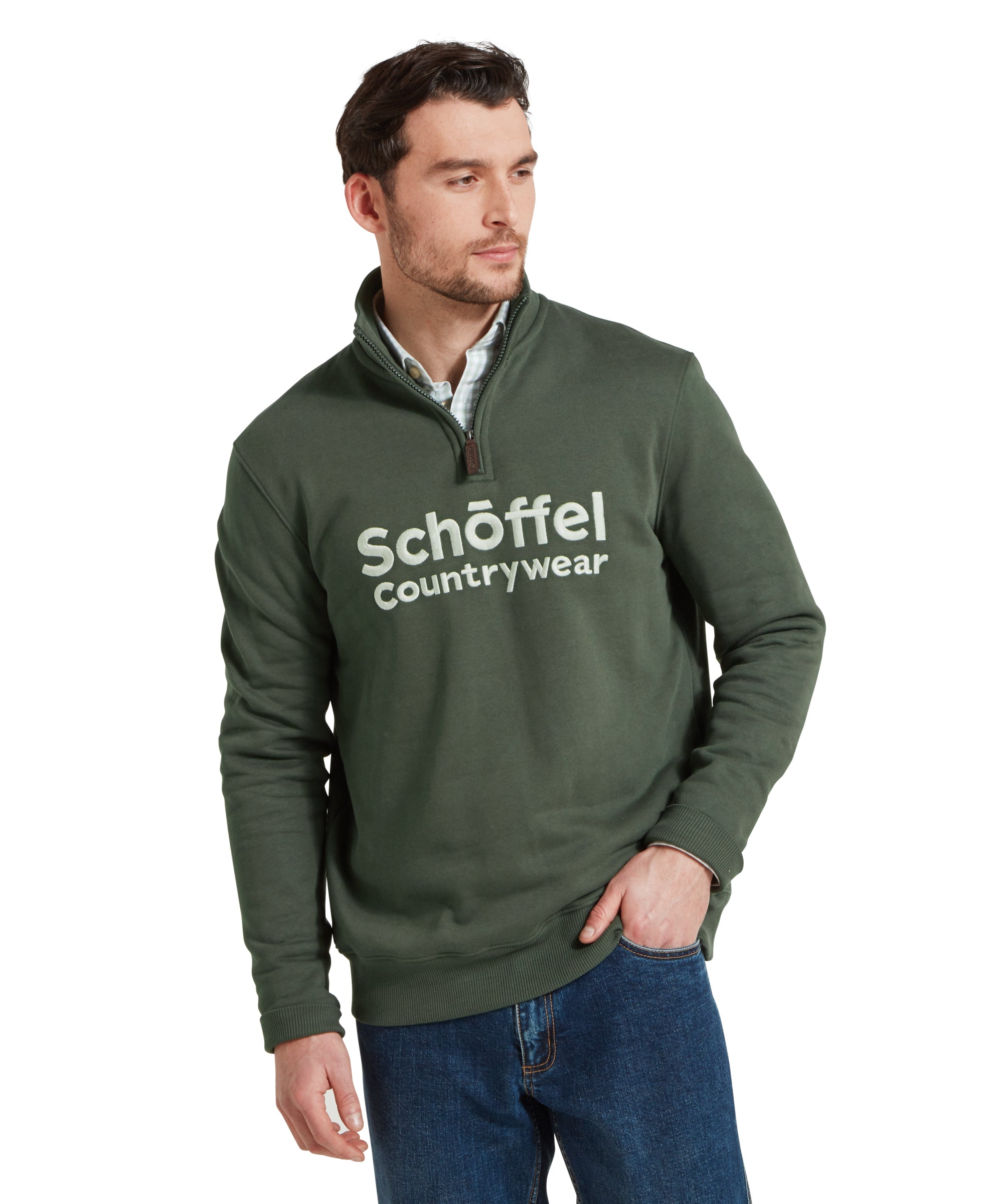 Half height view of a man standing in a relaxed pose, wearing the Schöffel Bude Sweatshirt for Men in Green, paired with jeans and checked shirt.