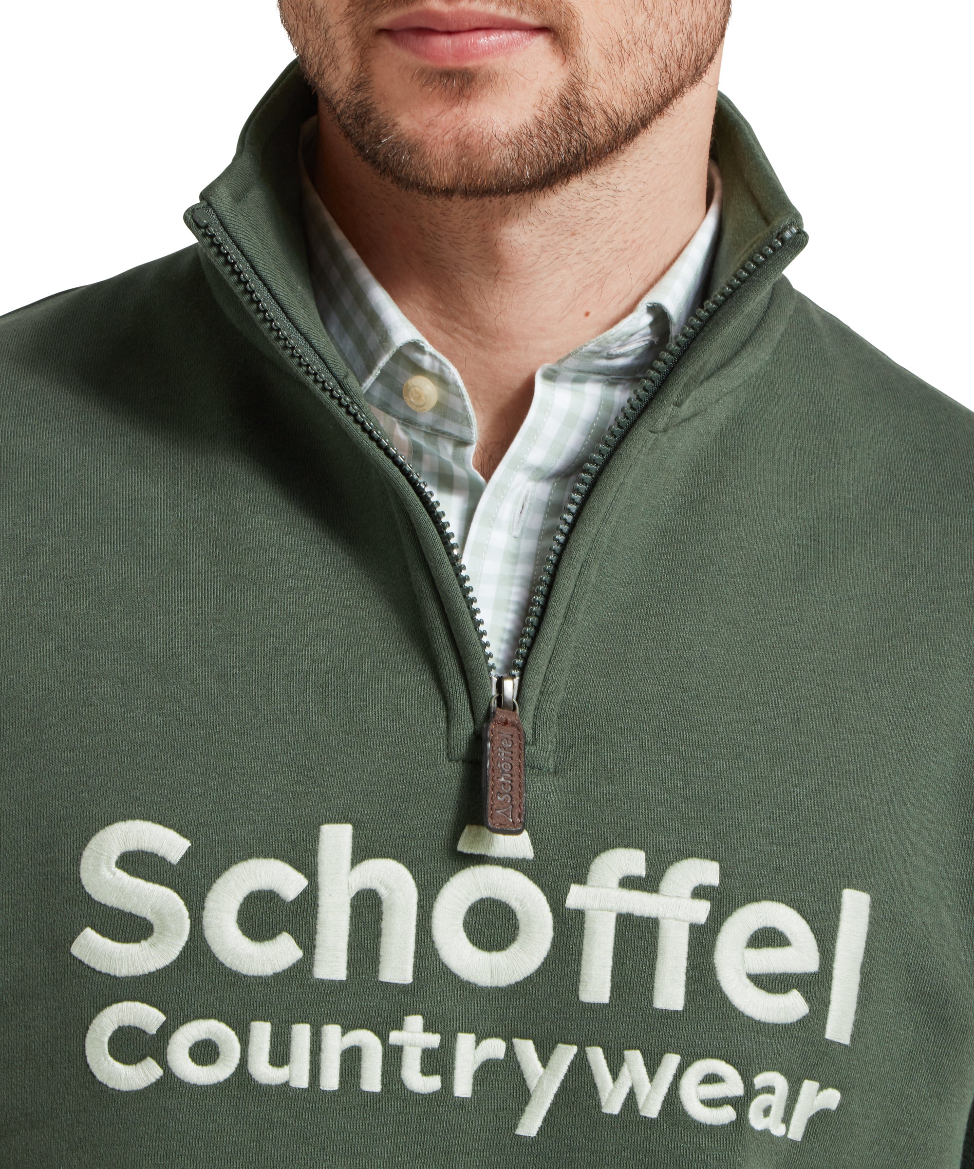 Close-up of the man's chest, highlighting the embroidered Schöffel Countrywear logo on the Schöffel Bude Sweatshirt for Men in Green.