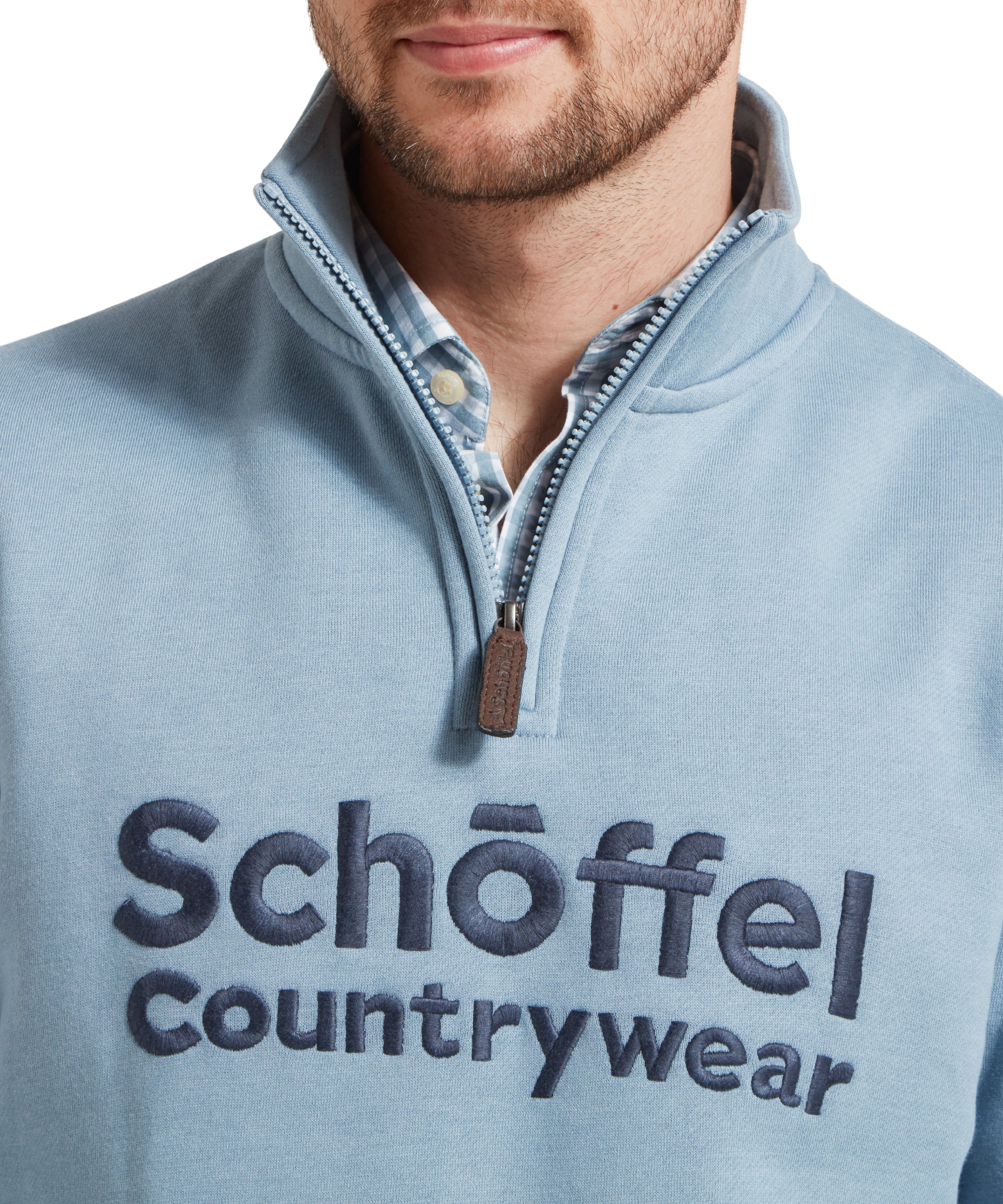 Close-up of the man's chest, highlighting the embroidered Schöffel Countrywear logo on the Schöffel Bude Sweatshirt for Men in Blue.