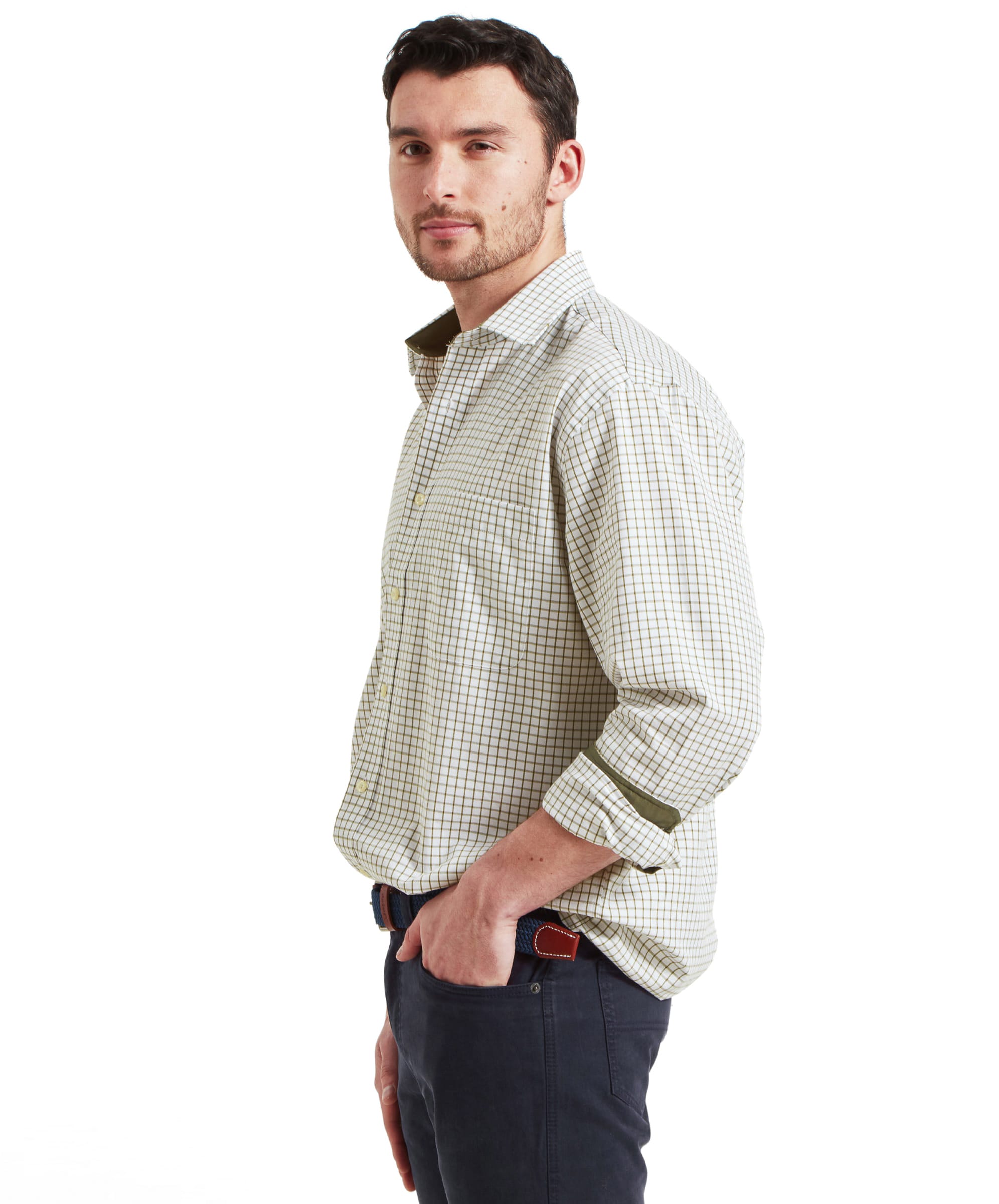 Side profile of the model wearing the Schöffel Cambridge Classic Shirt for Men in Green, with hands in pockets and a slight smile.