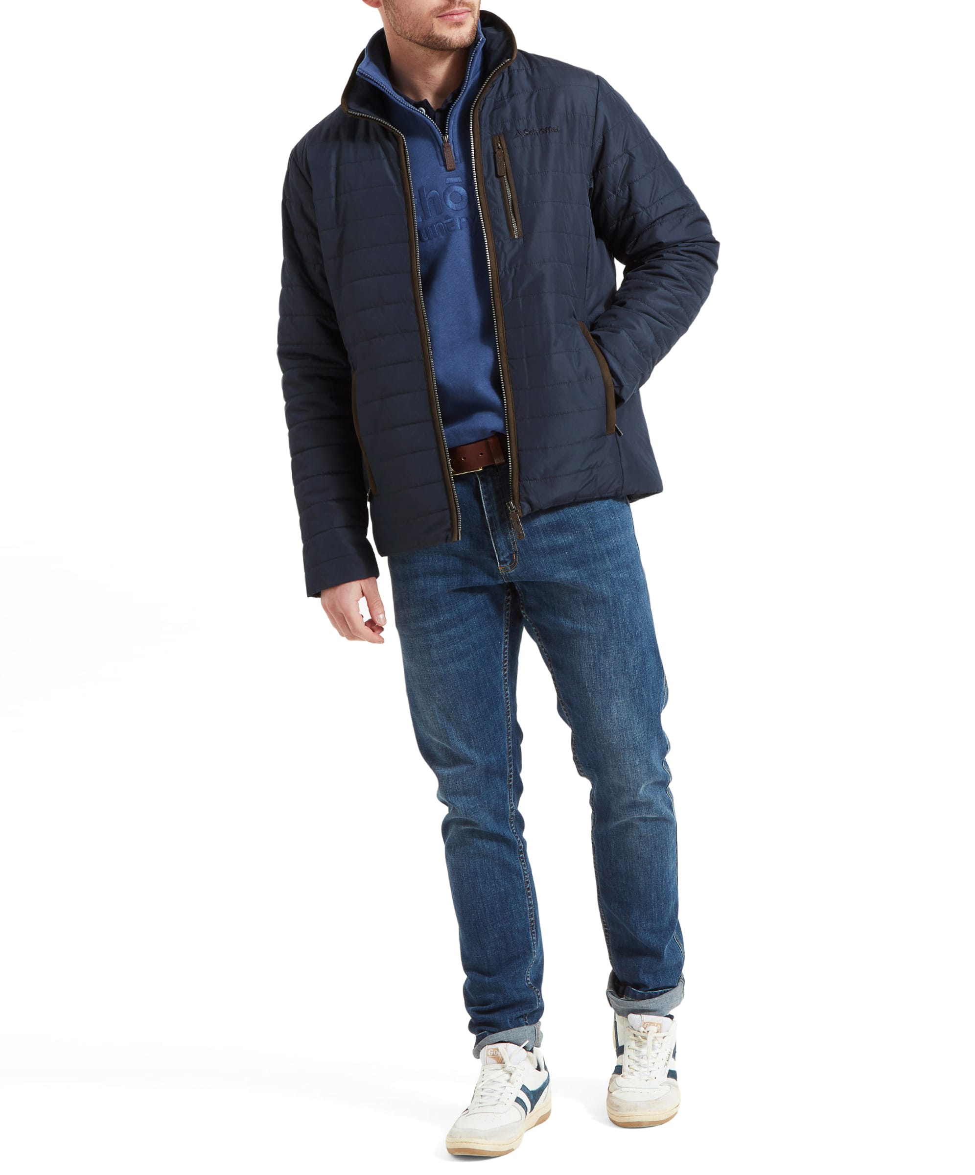 The model in the Schöffel Carron Jacket for Men in Navy, standing with a relaxed pose, hands in pockets, showcasing the outfit with jeans and trainers.