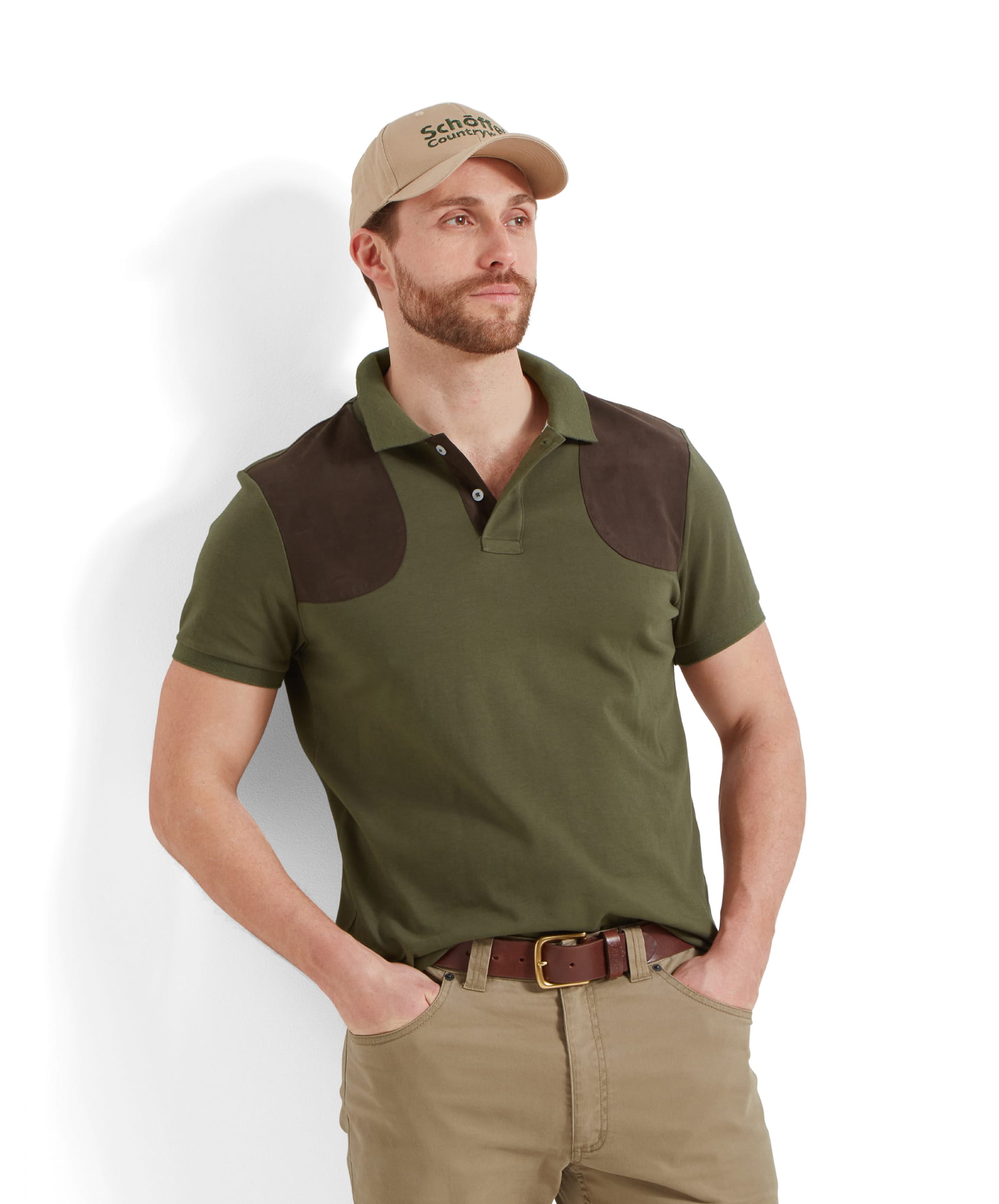 A model wearing the Schöffel Cordoba Polo Shirt for Men in Green, featuring dark brown shoulder patches and a beige cap.