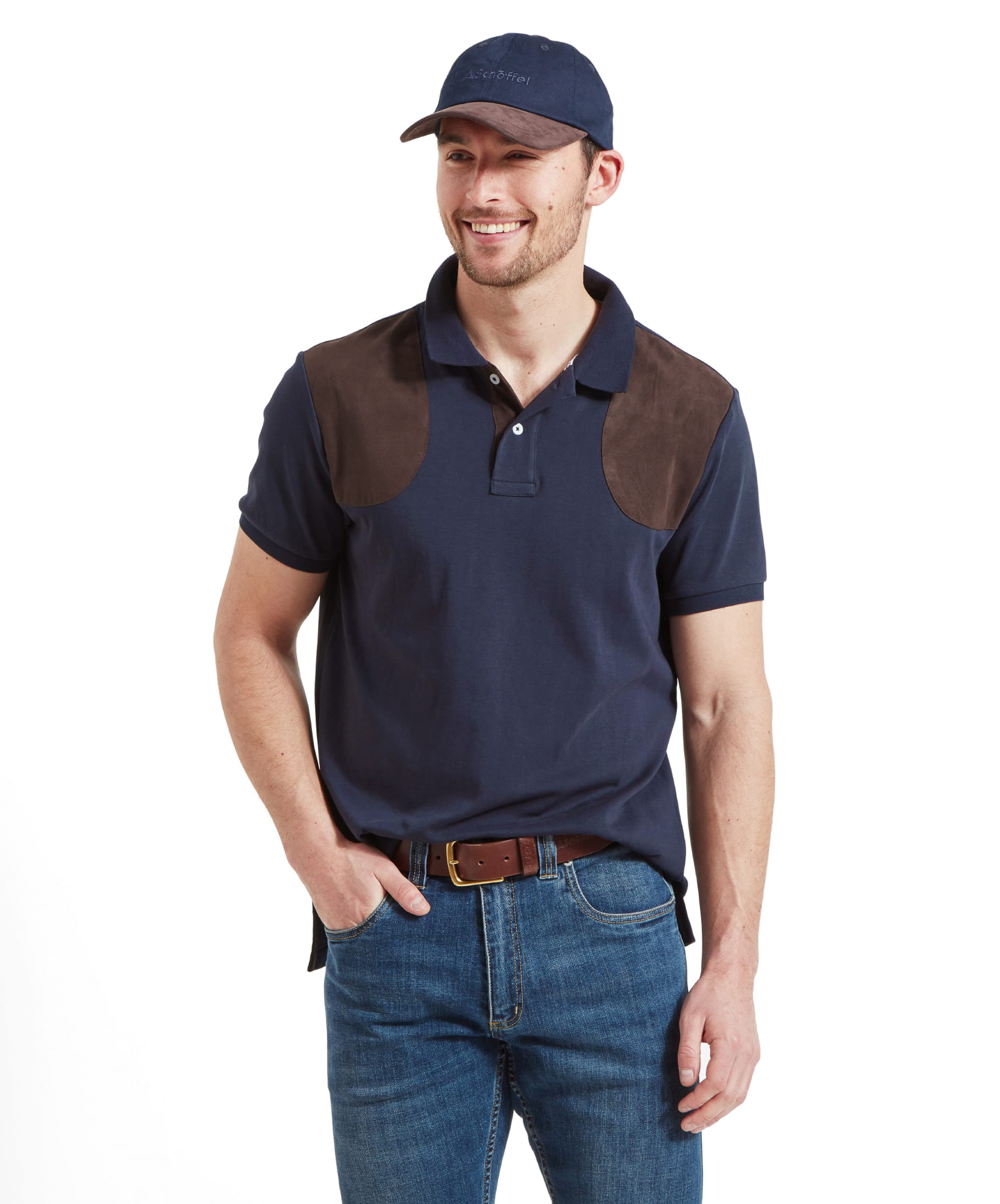 A man wearing a Schöffel Cordoba Polo Shirt for Men in Navywith brown shoulder patches, paired with blue jeans and a brown belt.