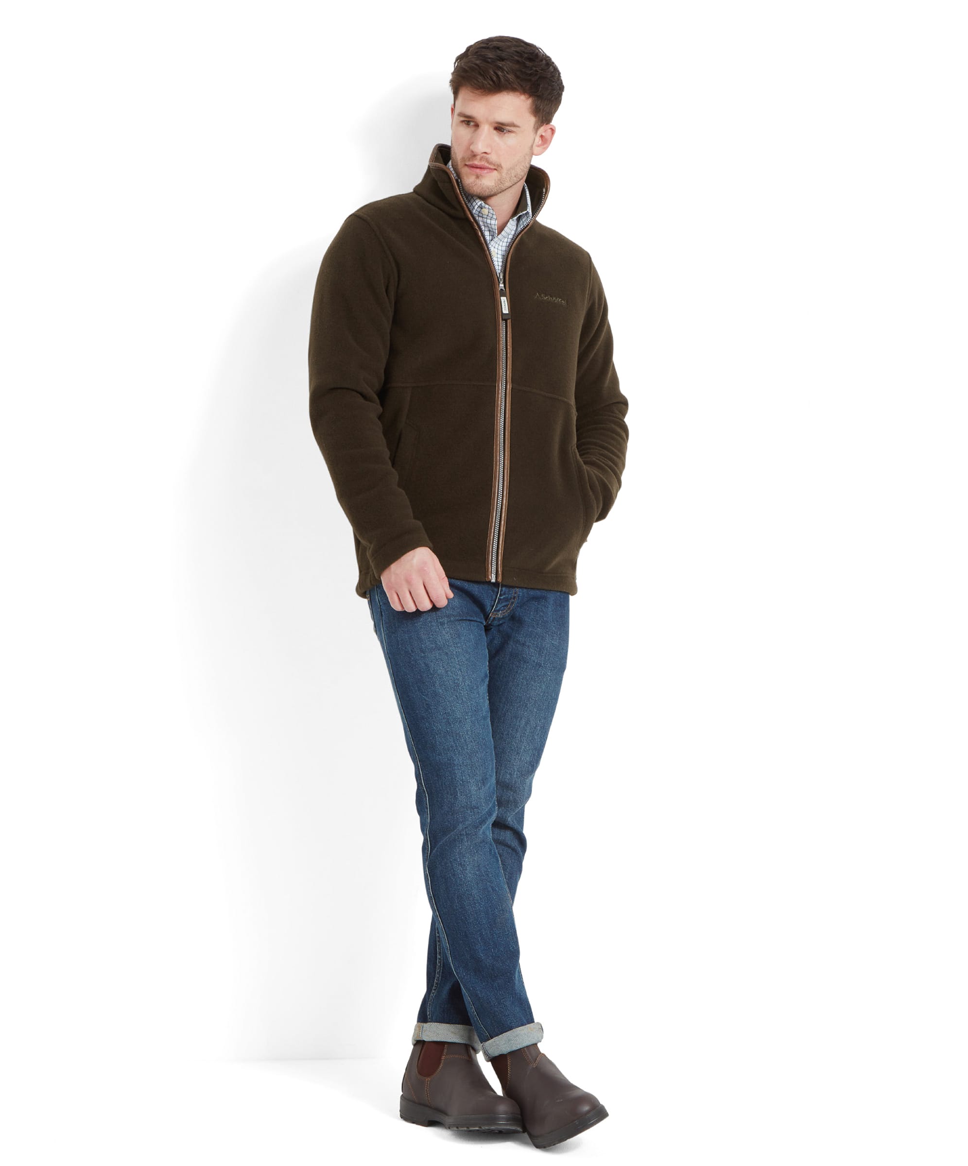 A full-body image of the man in a dark green Schöffel Cottesmore Fleece Jacket for Men in Dark Green and blue jeans, standing casually.