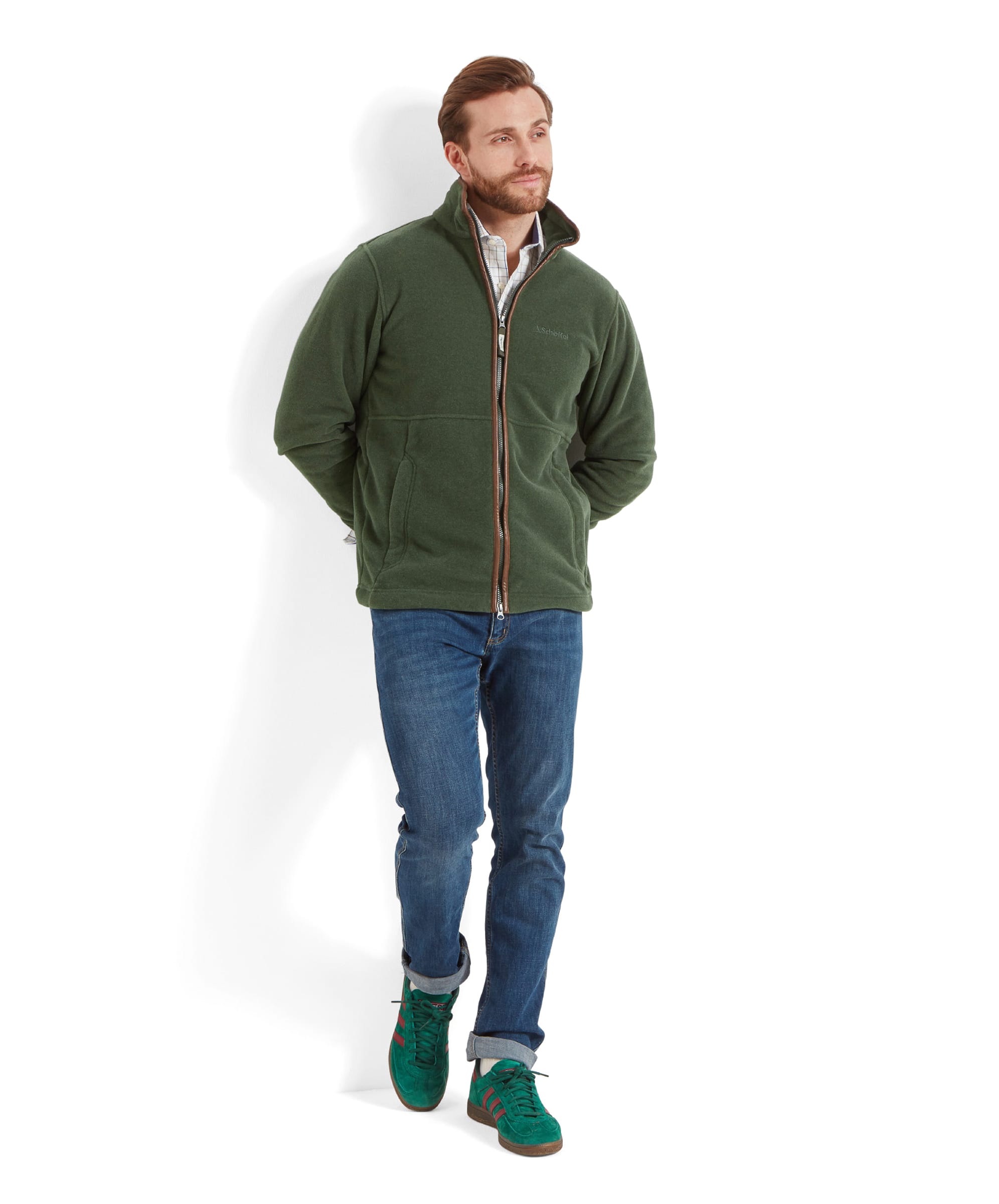 Full-body shot of the model walking, highlighting the Schöffel Cottesmore Fleece Jacket for Men in Green's fit and style.