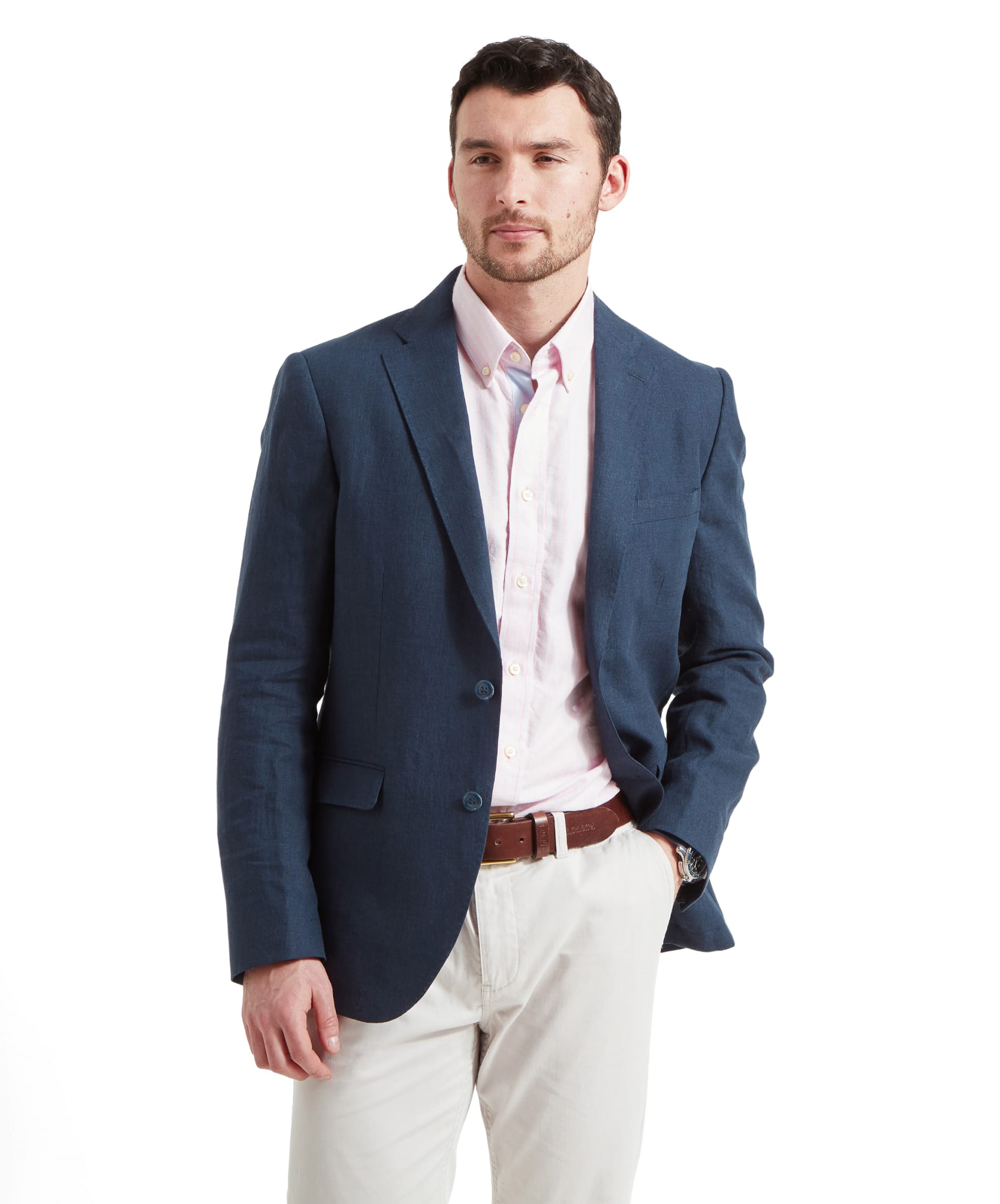 A man wearing the Schöffel Cowes Linen Jacket for Men in Navy, paired with a pink shirt and white trousers.