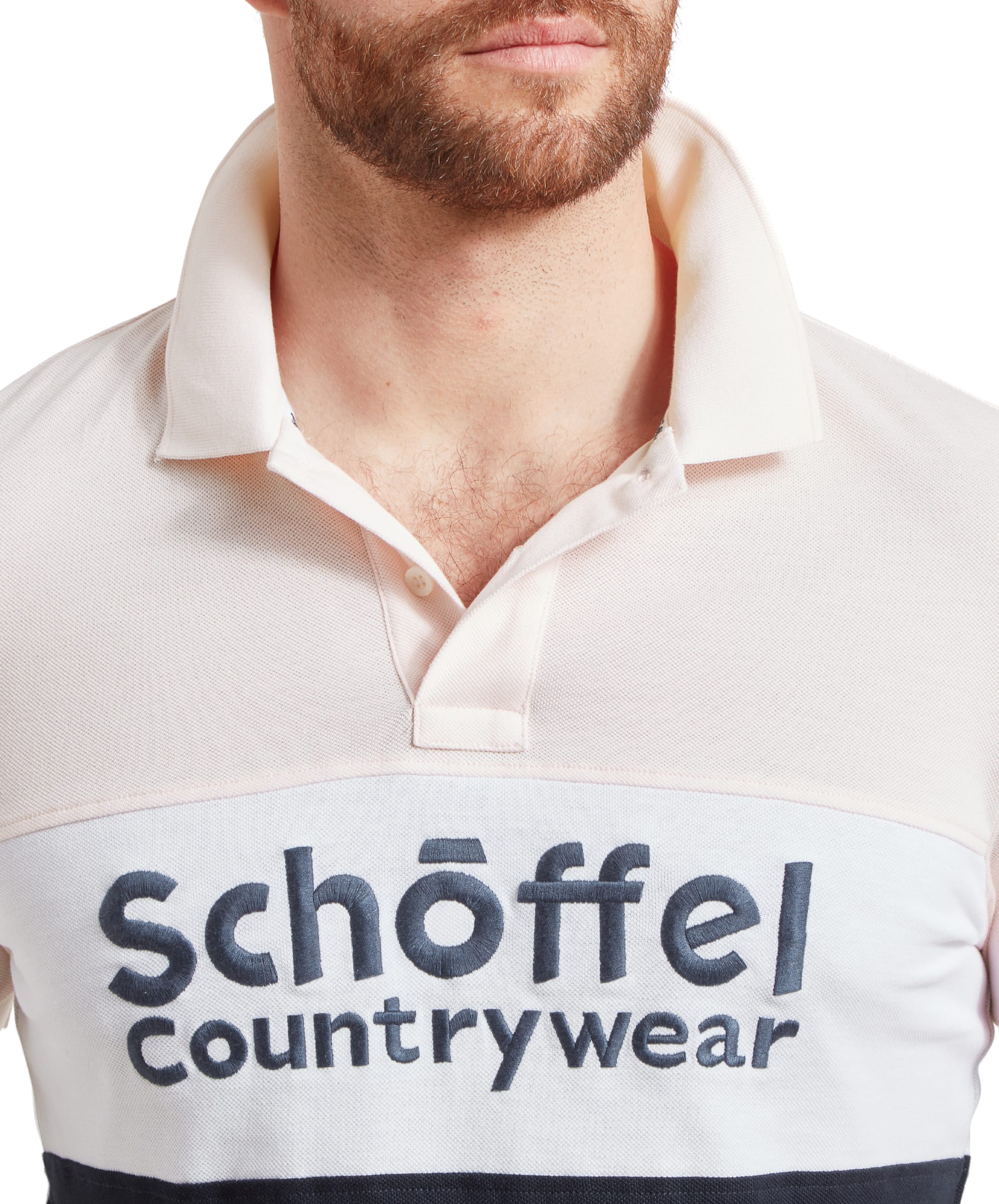 A close-up view of the man wearing the Schöffel Exeter Heritage Polo Shirt for Men in Pink, focusing on the embroidered logo on the chest.