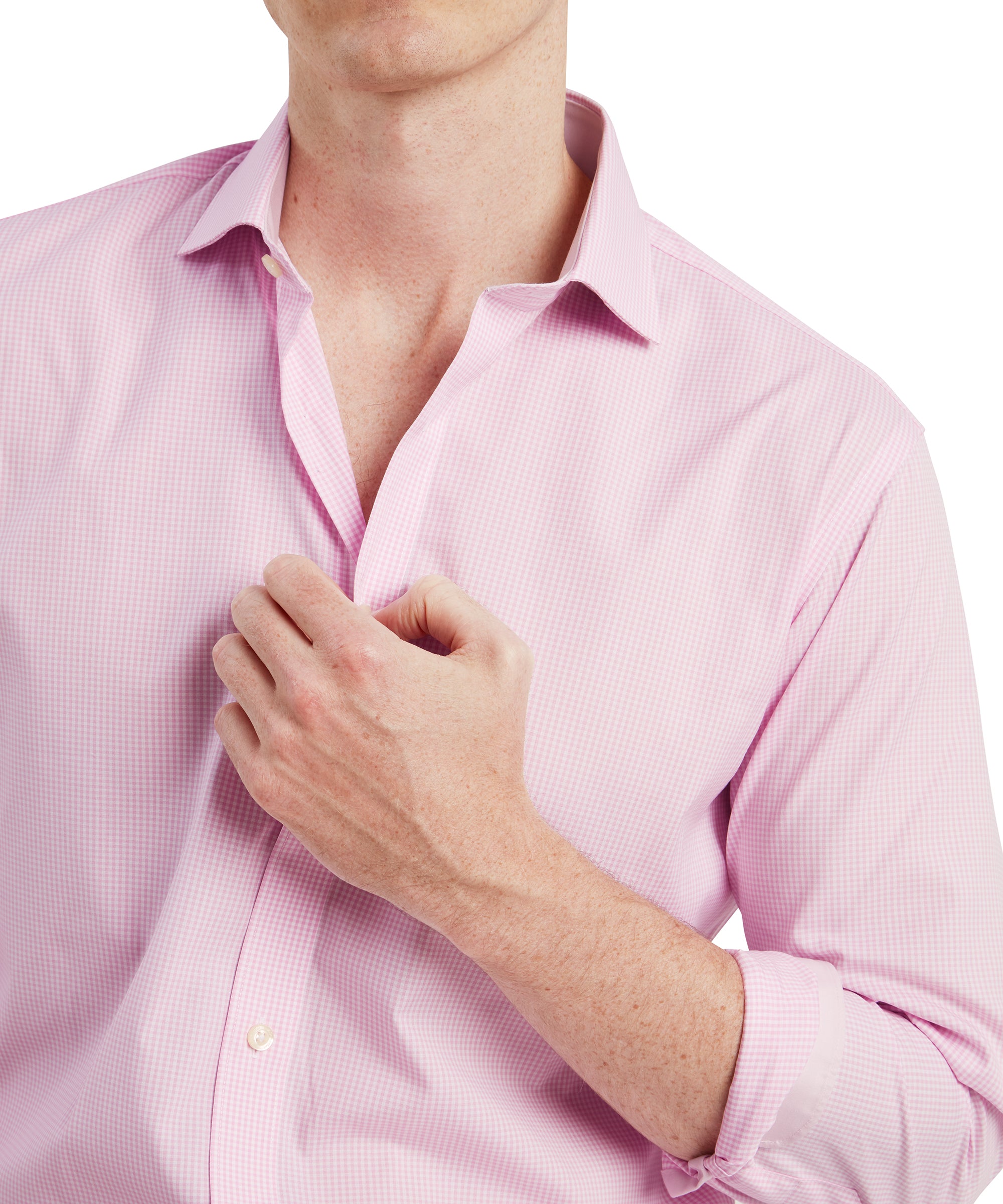 A close-up shot focusing on the upper chest area of the man in the Schöffel Greenwich Tailored Shirt for Men in Pink Check. He lightly grasps the shirt collar with his right hand, emphasising the crispness of the collar and the fine checkered pattern of the shirt. The subtle pink and white check pattern gives the shirt a refined and elegant appearance.