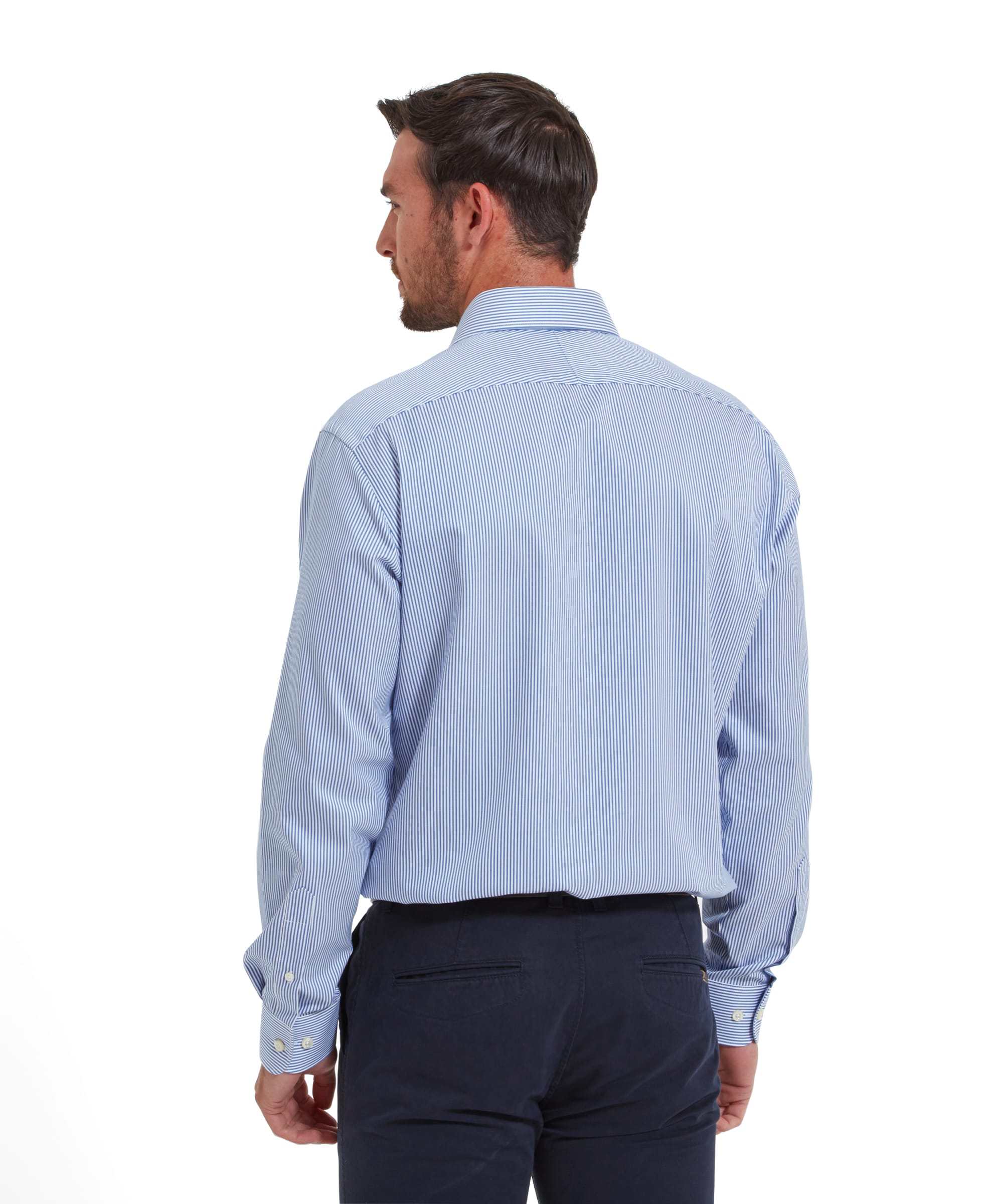 The man is turned away from the camera, showing the back of the Schöffel Greenwich Tailored Shirt for Men in Navy Stripe. The shirt has a comfortable fit, with neat stitching and a clean design.