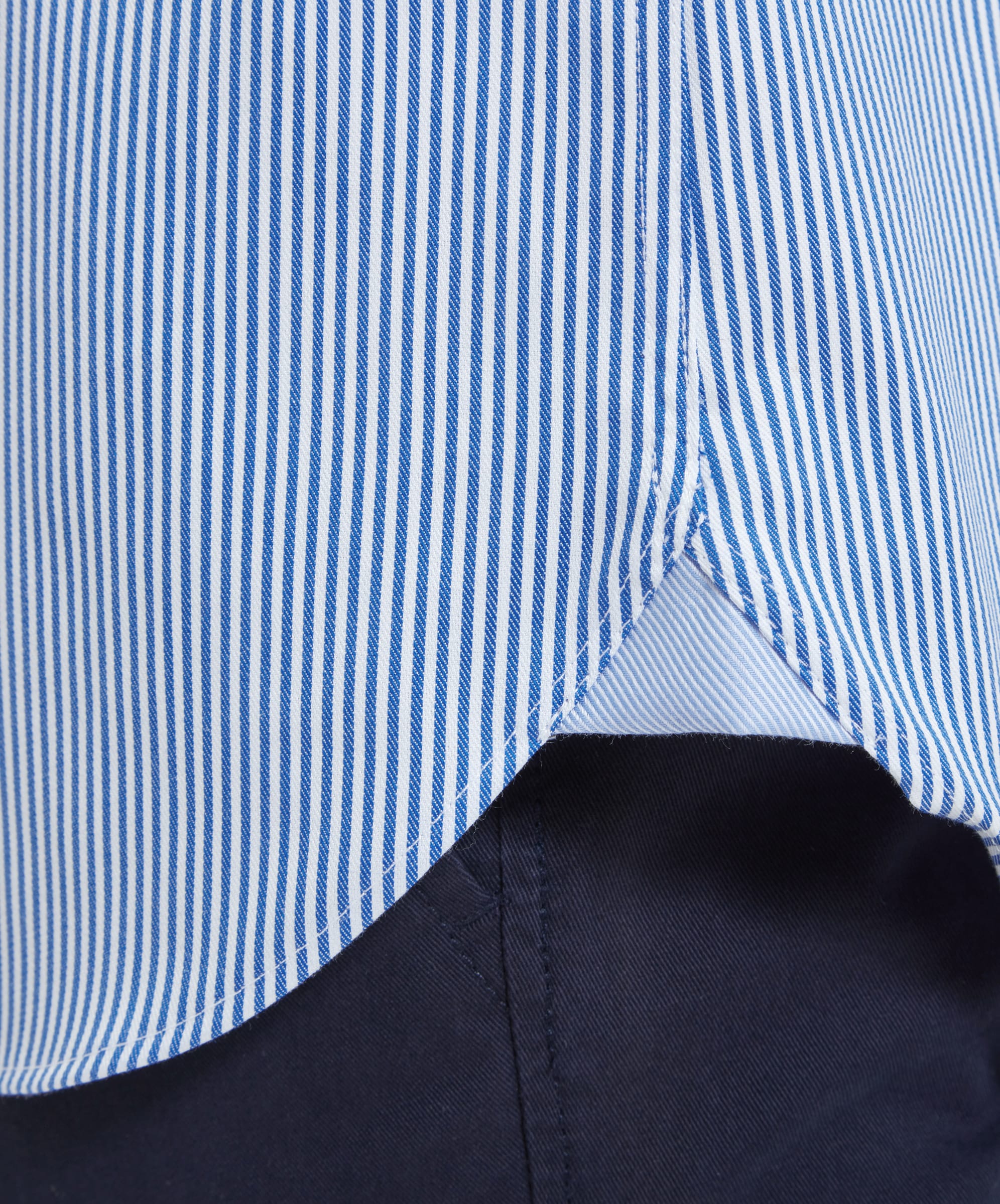 A detailed view of the shirt's gusset hem, showing the Schöffel Greenwich Tailored Shirt for Men in Navy Stripe. The hem is neatly finished, with precise stitching, emphasizing the high-quality craftsmanship of the shirt.