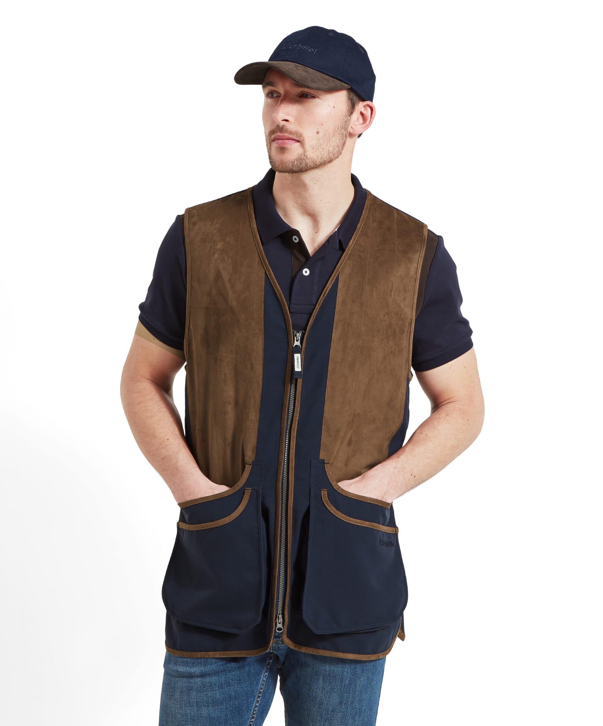 A man in the Schöffel Grimsthorpe Clay Shooting Vest for Men in Blue, standing with hands in pockets, wearing a navy cap.