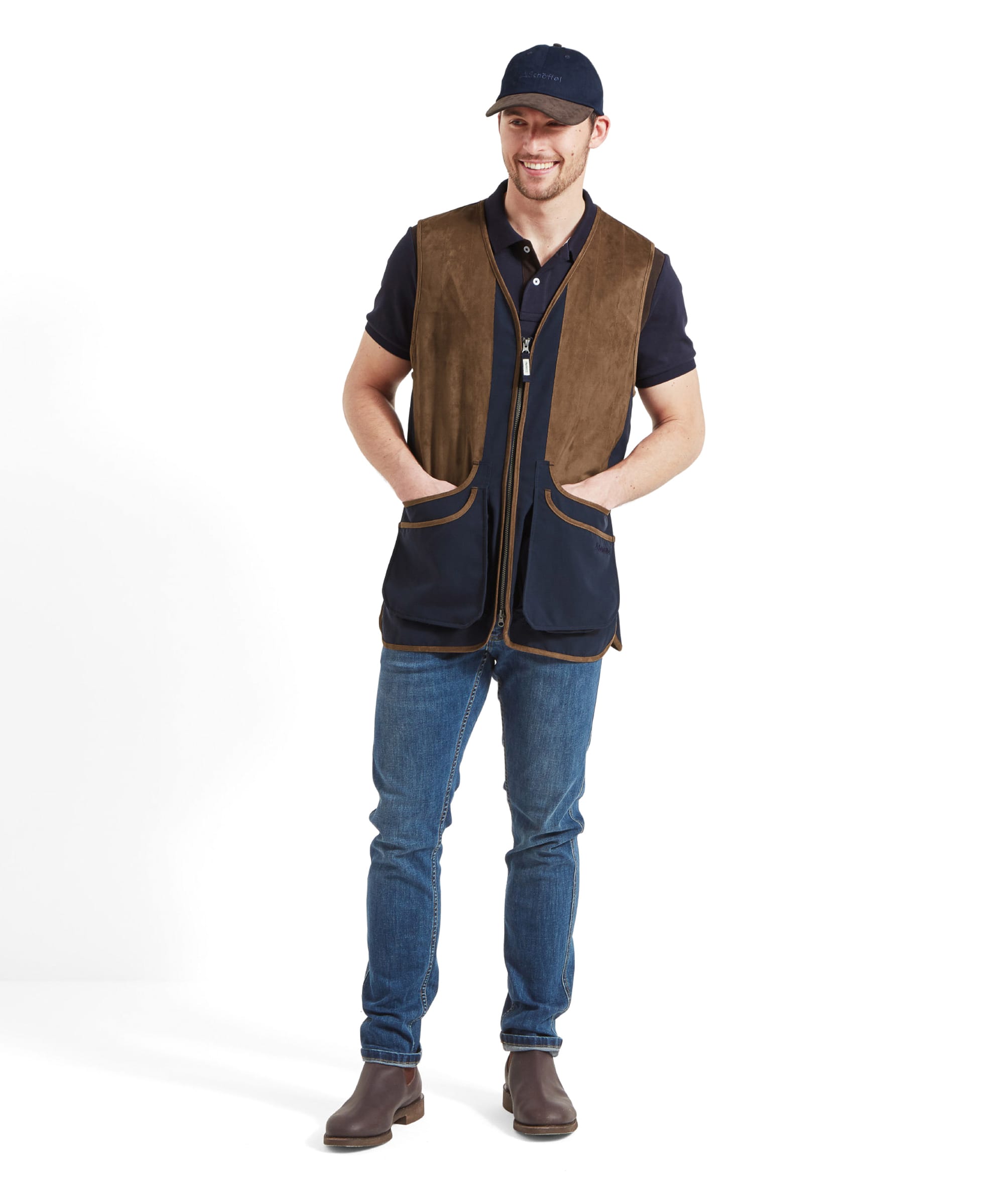 Full-body view of a man wearing the Schöffel Grimsthorpe Clay Shooting Vest for Men in Blue, paired with jeans and brown boots.