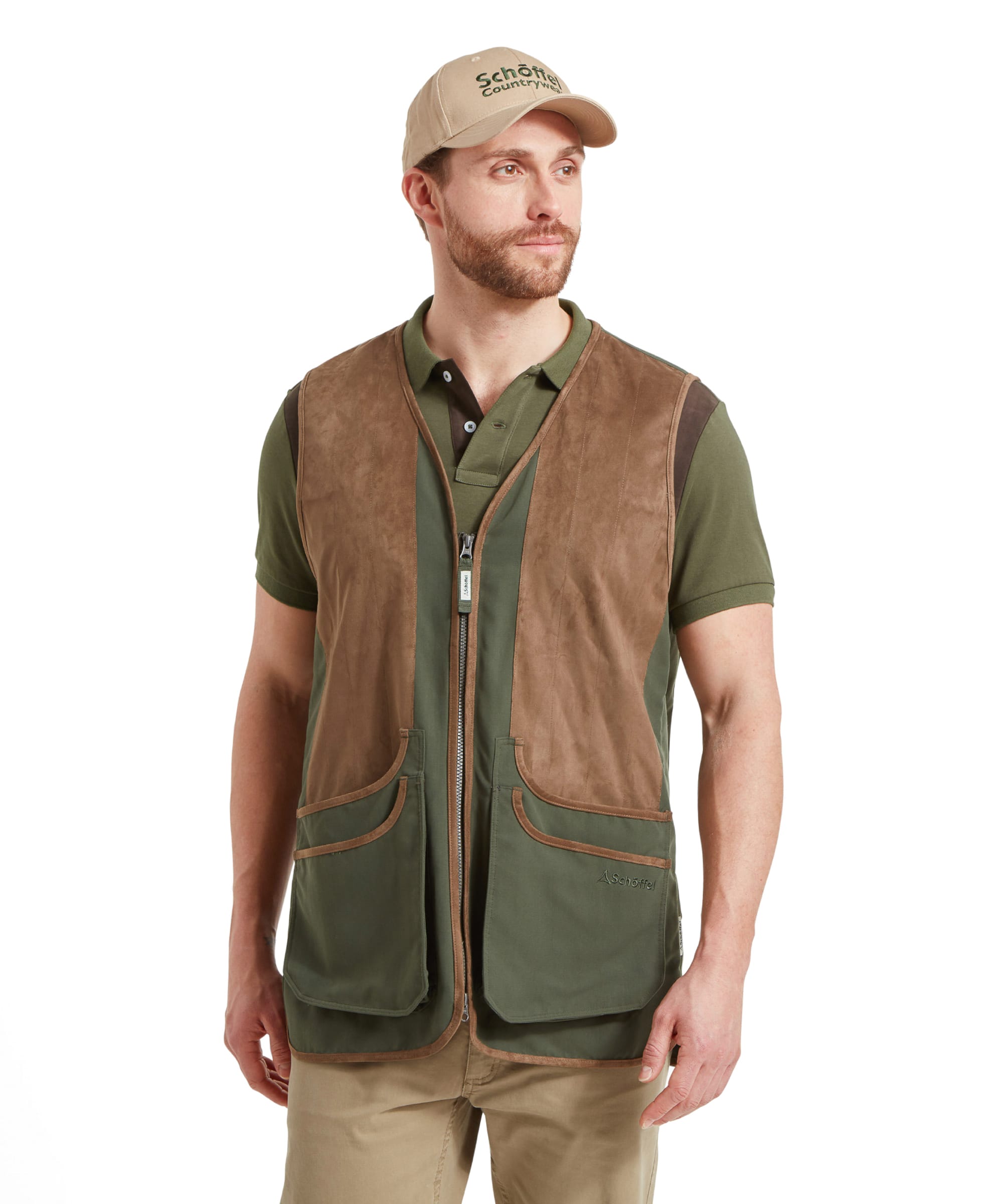 A man in the Schöffel Grimsthorpe Clay Shooting Vest for Men in Green, standing with hands to his sides, looking to the right, wearing a beige cap.