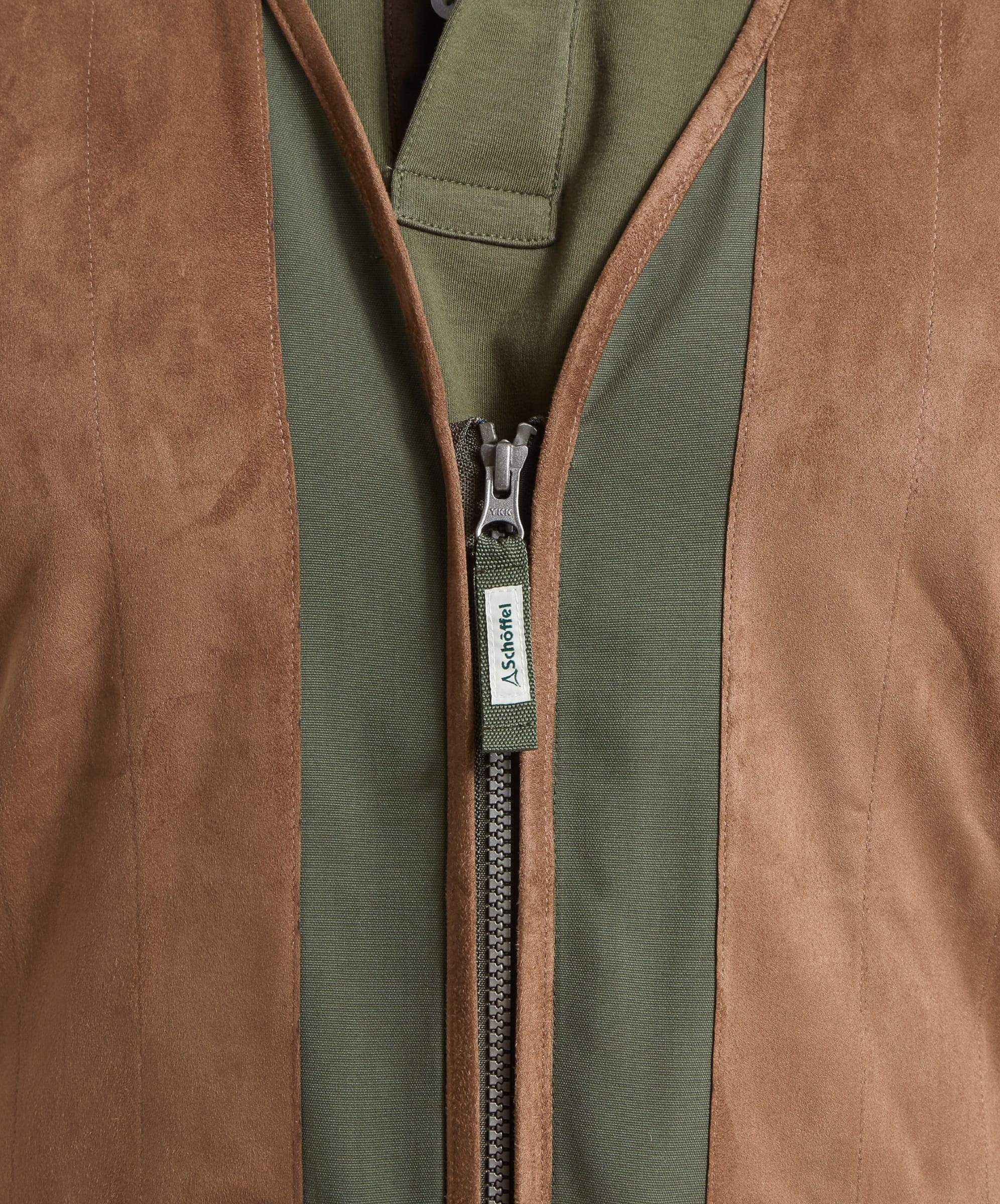 Close-up of the front zipper of the Schöffel Grimsthorpe Clay Shooting Vest for Men in Green, highlighting the logo pull and suede chest.