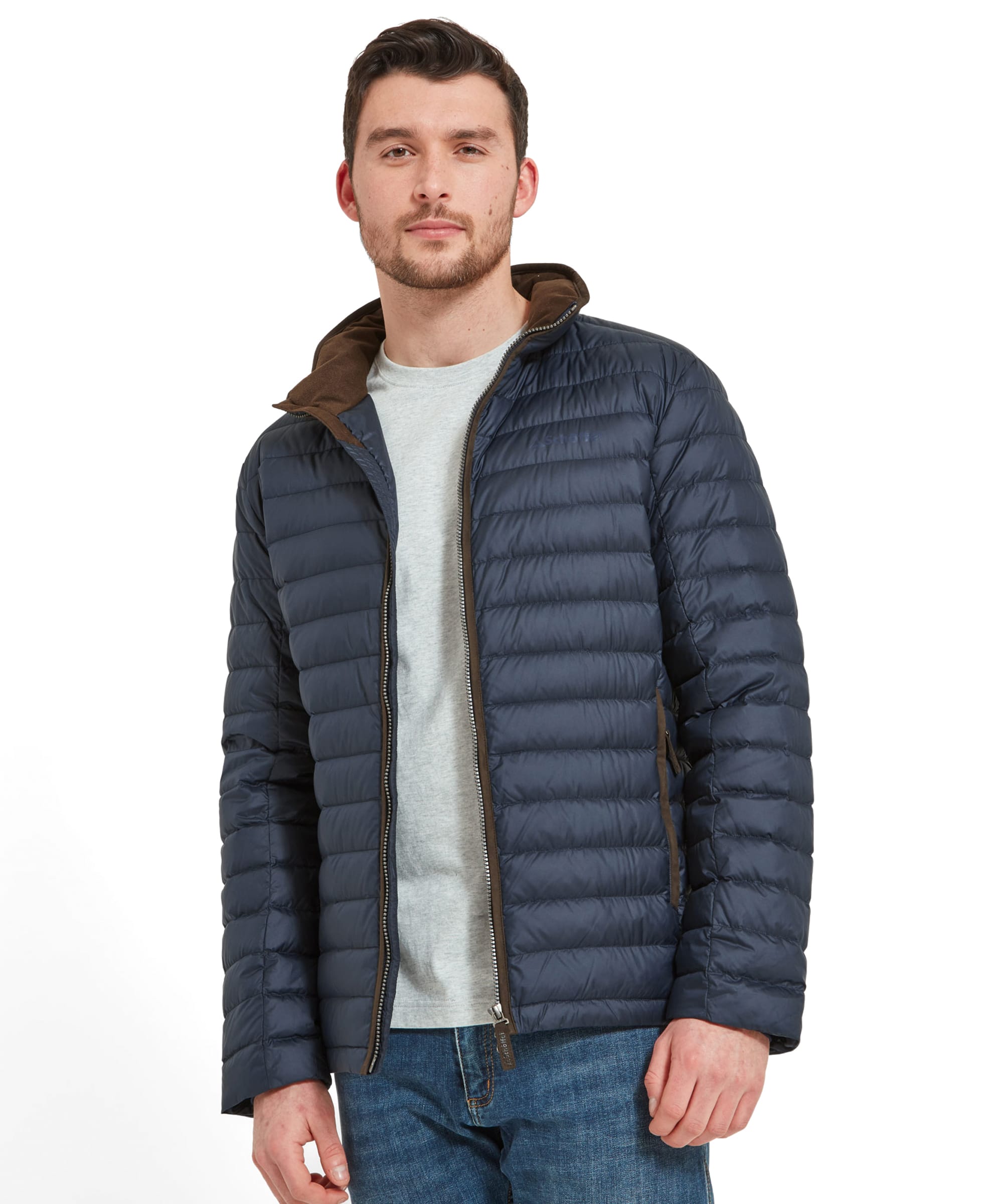 A model wears the Schöffel Hallaton Down Jacket for Men in Blue opened with his hands to his side. He wears blue jeans and grey t-shirt.