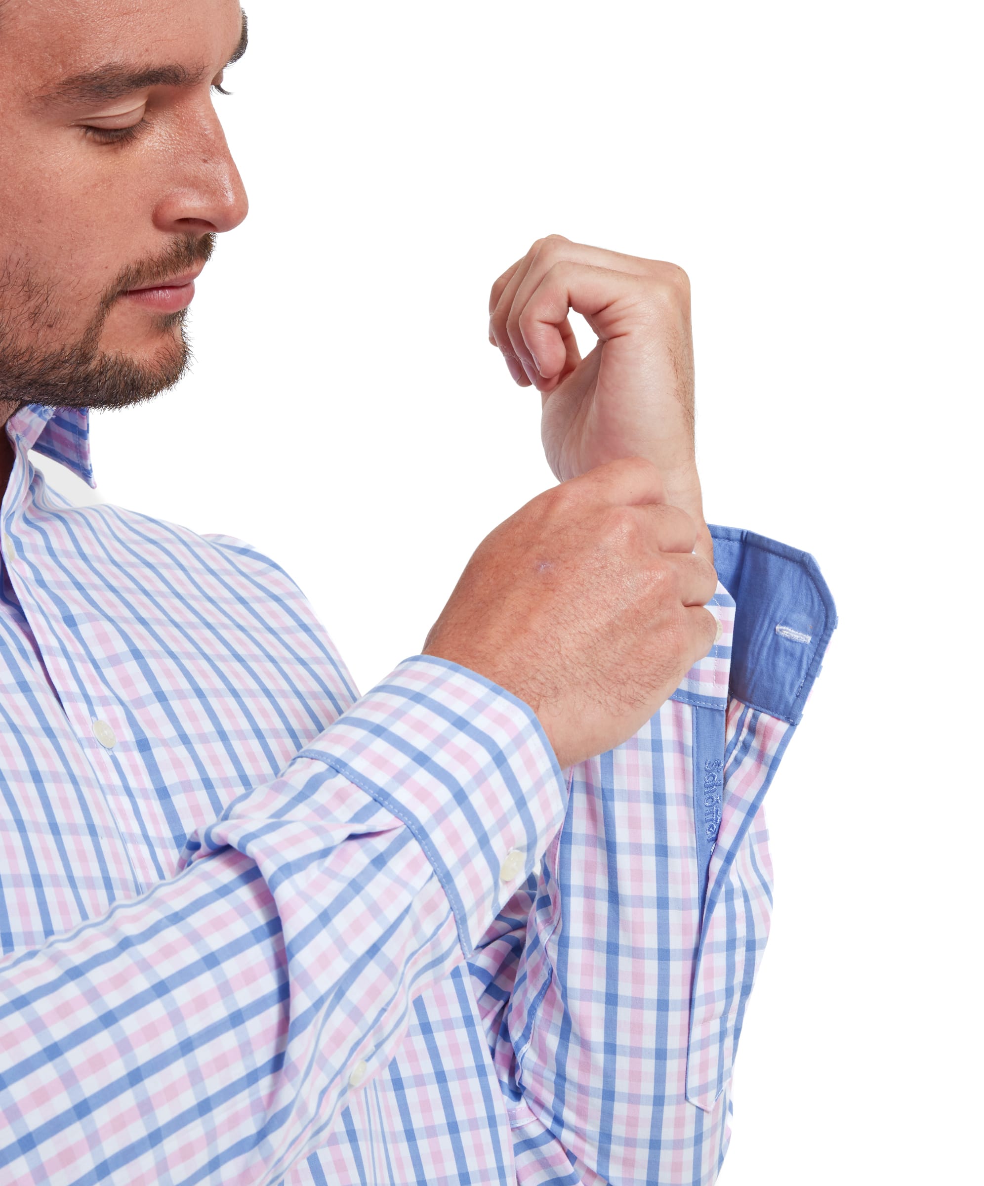 Close-up of a man adjusting the buttons of the cuff of the Schöffel Hebden Tailored Shirt for Men in Blue and Pink, displaying the light blue cuff lining on the interior.