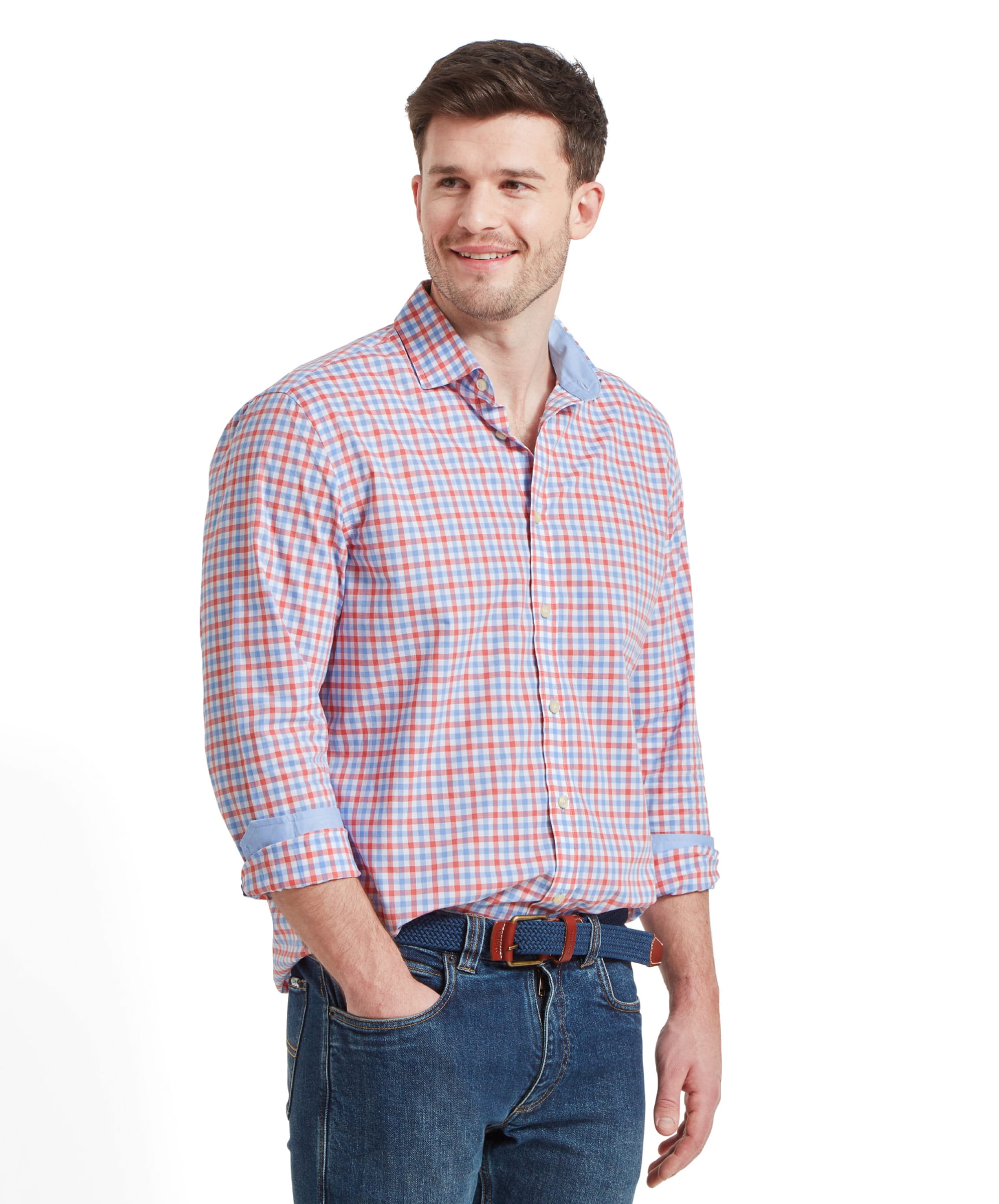 Side view of a man wearing the Schöffel Hebden Tailored Shirt for Men in Coral and Blue with his right hand in his jeans pocket. He's looking to the left and smiling.