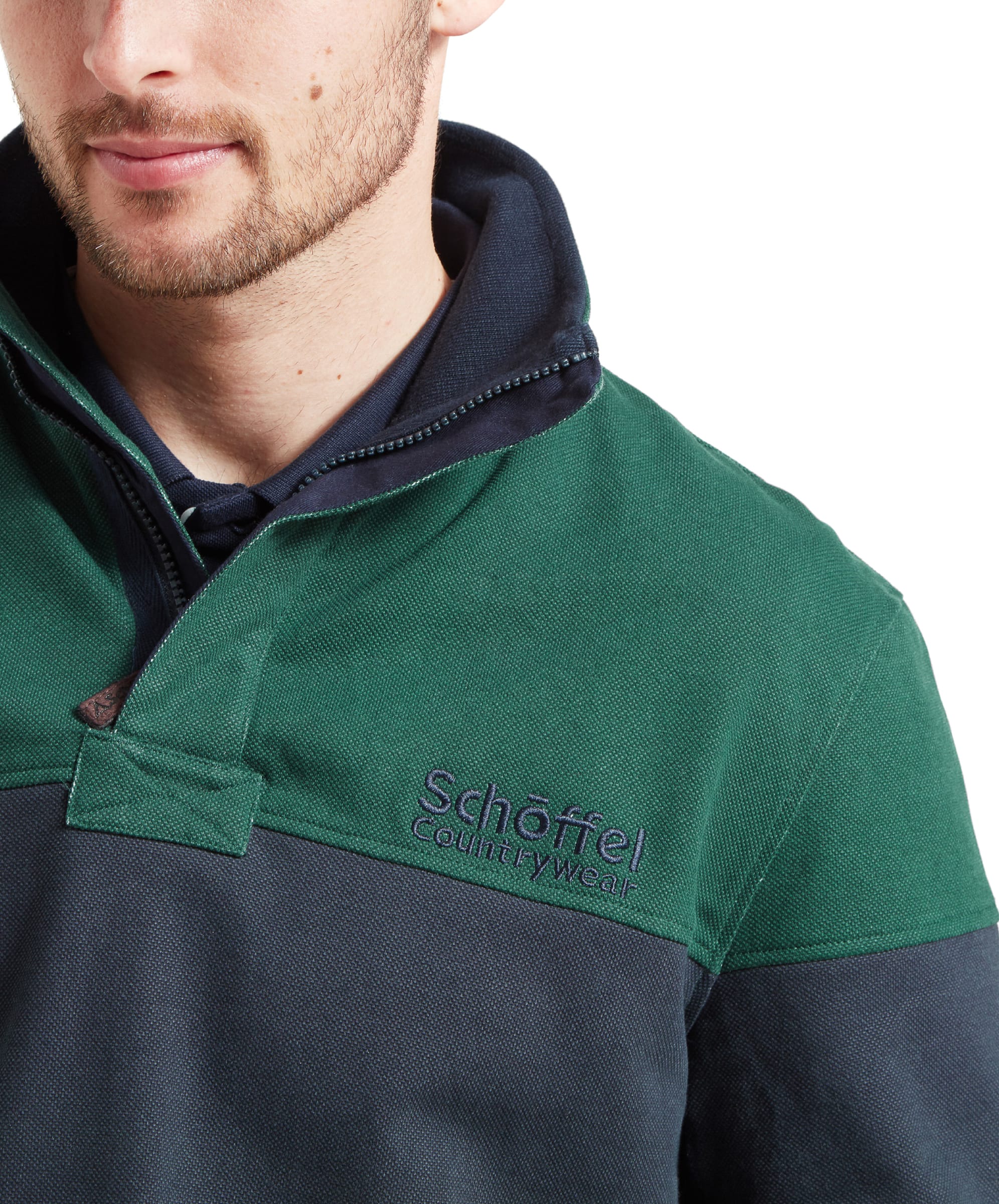 Close-up of the Schöffel Helford Heritage Sweatshirt for Men in Green highlighting the navy blue embroidery of the Schöffel Countrywear logo on the right chest. The collar is a zipped design.