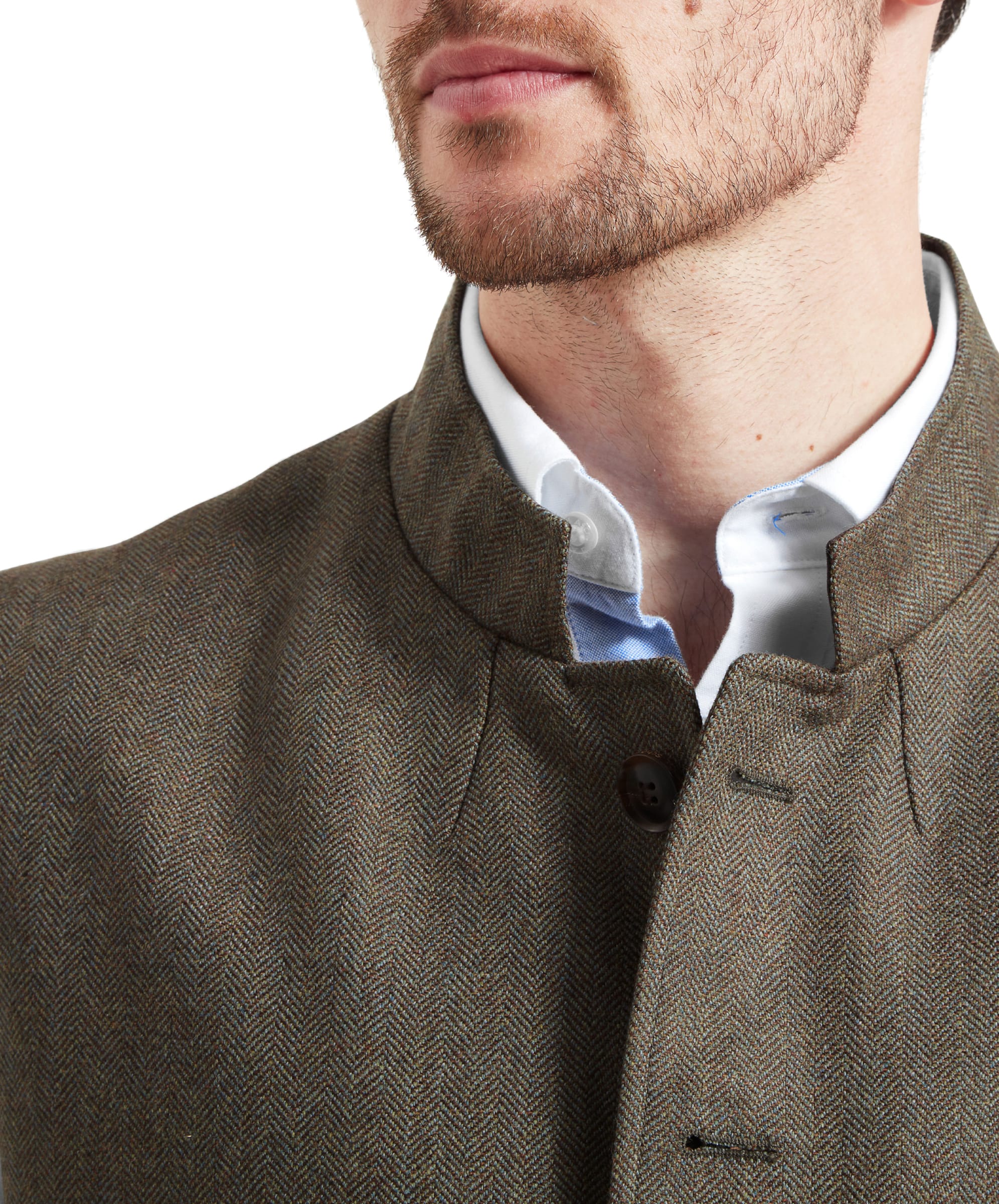 Close-up of the Schöffel Holcot Tweed Waistcoat for Men in Green highlighting the collar darts on the front. The fabric is a green mixed herringbone and the front placket features dark brown buttons. Model wears with a white shirt underneath.