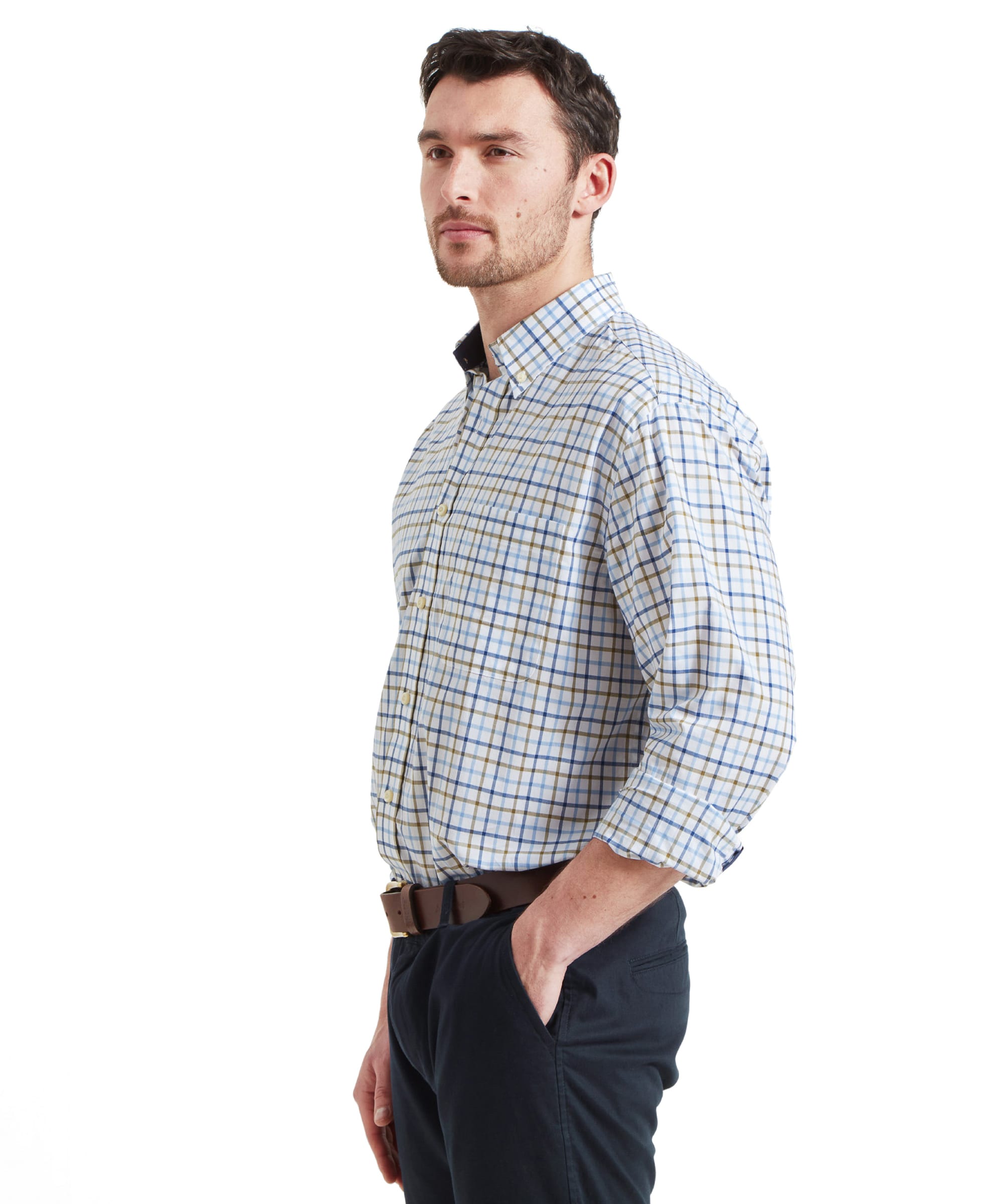 Side view of the Schöffel Holkham Classic Shirt for Men in Navy as the model has his right hand in his trouser pocket. The sleeves are rolled up his forearms.