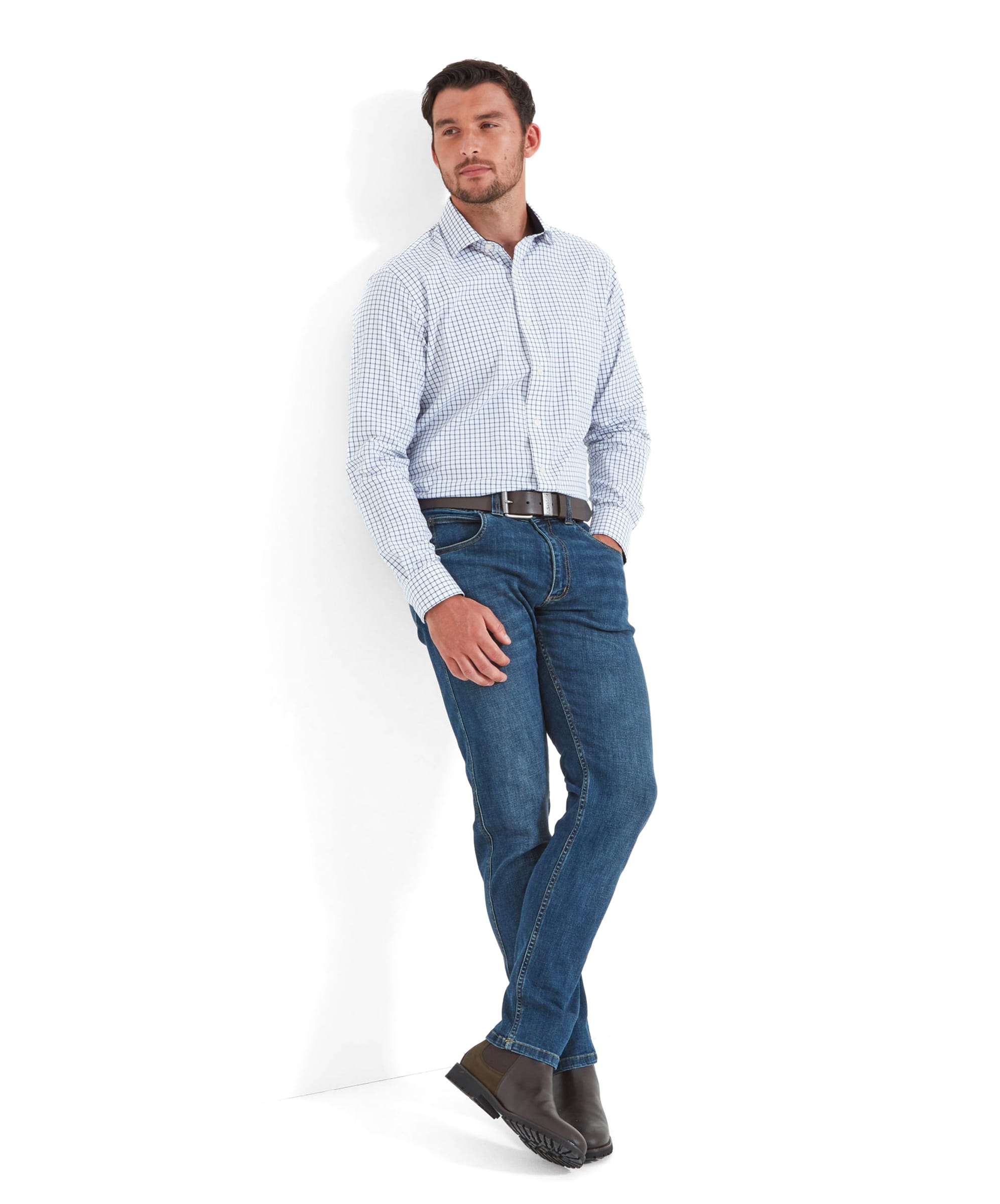 Full body view of a model wearing the Schöffel James Jean for Men in Blue with a navy checkered shirt, a dark brown leather belt, and dark brown leather boots.