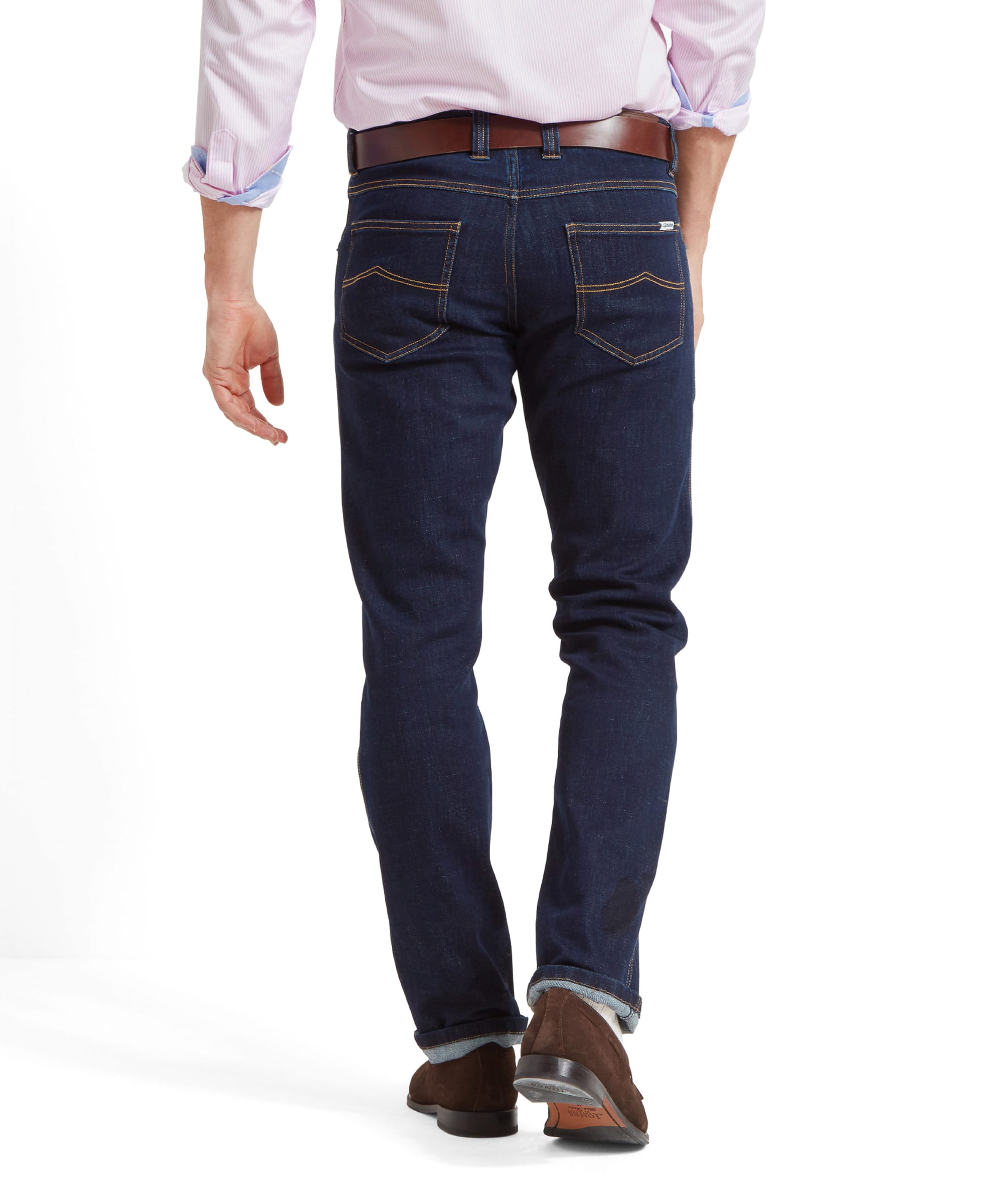 Back view of the Schöffel James Jean for Men in Navy highlighting the back pockets which have been finished with a golden top stitch. Model wears a tan leather belt and brown loafers with the jeans slightly rolled up at the hem.