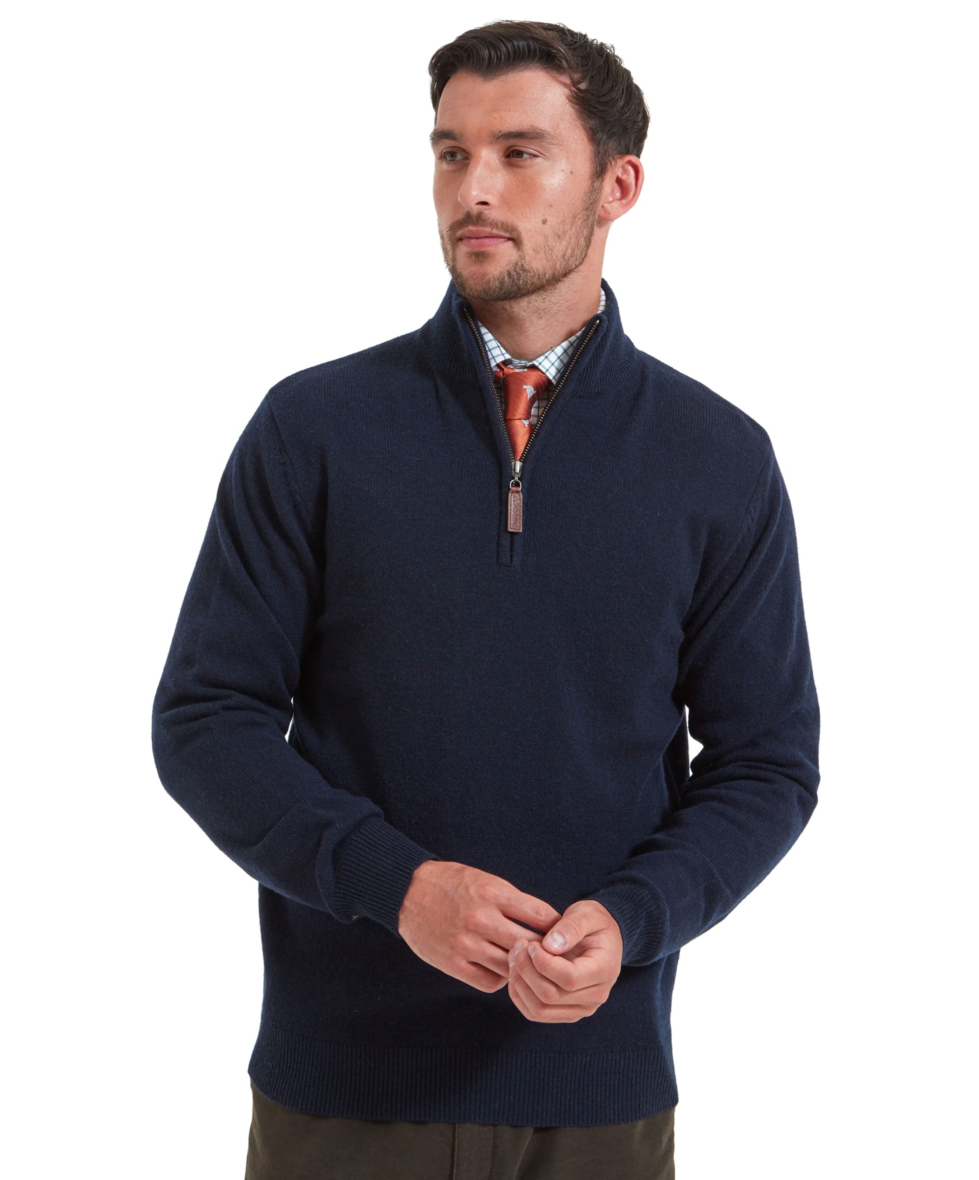 A man wears a Schöffel Lambswool 1/4 Zip for Men in Navy with brown trousers, a checked shirt and an orange tie. He is adjusting his cuff and looking to his left.