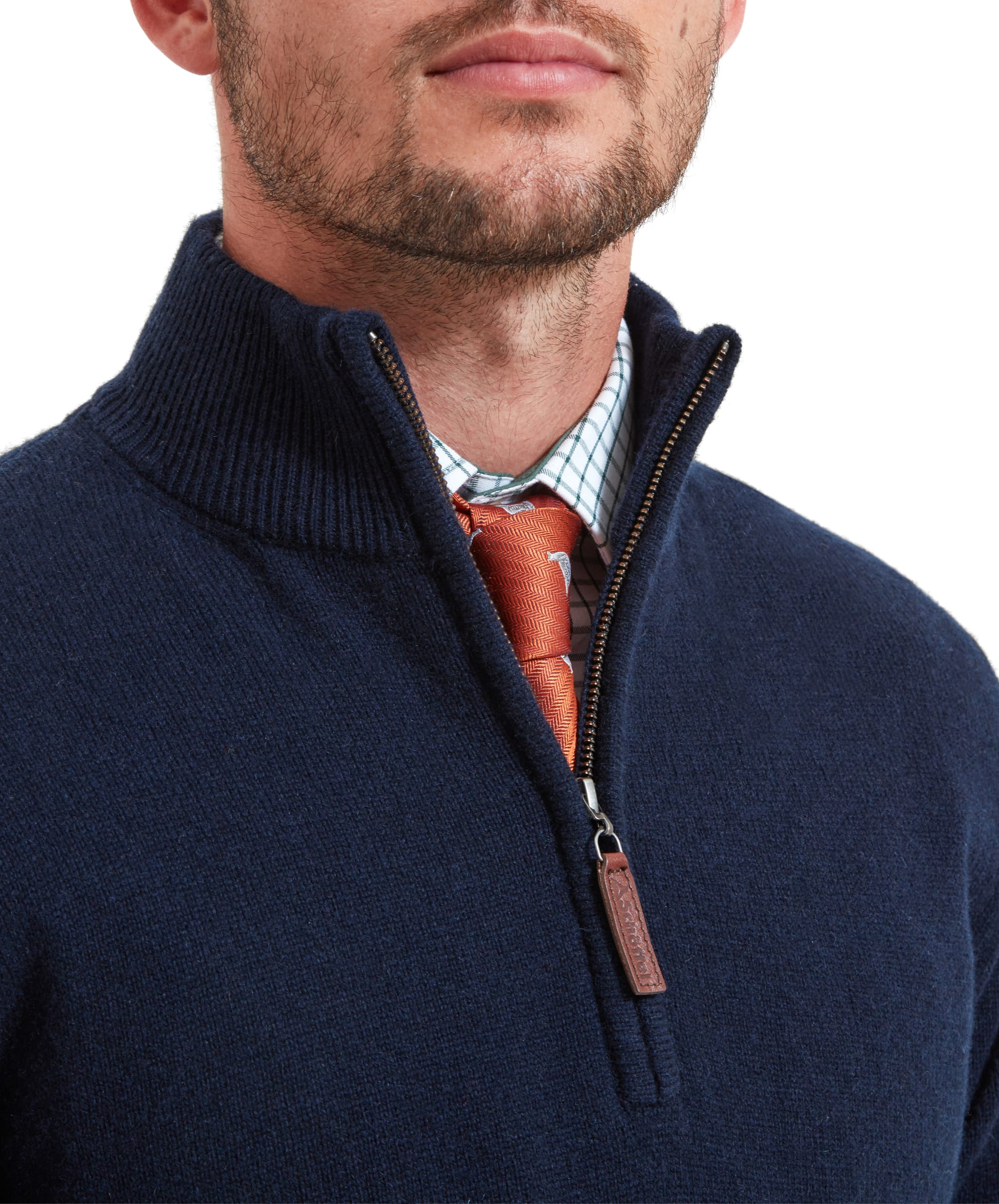 Close-up of the zip area  of the Schöffel Lambswool 1/4 Zip for Men in Navy, the man wears a checked shirt with an orange tie, highlighting the faux leather zip tab.