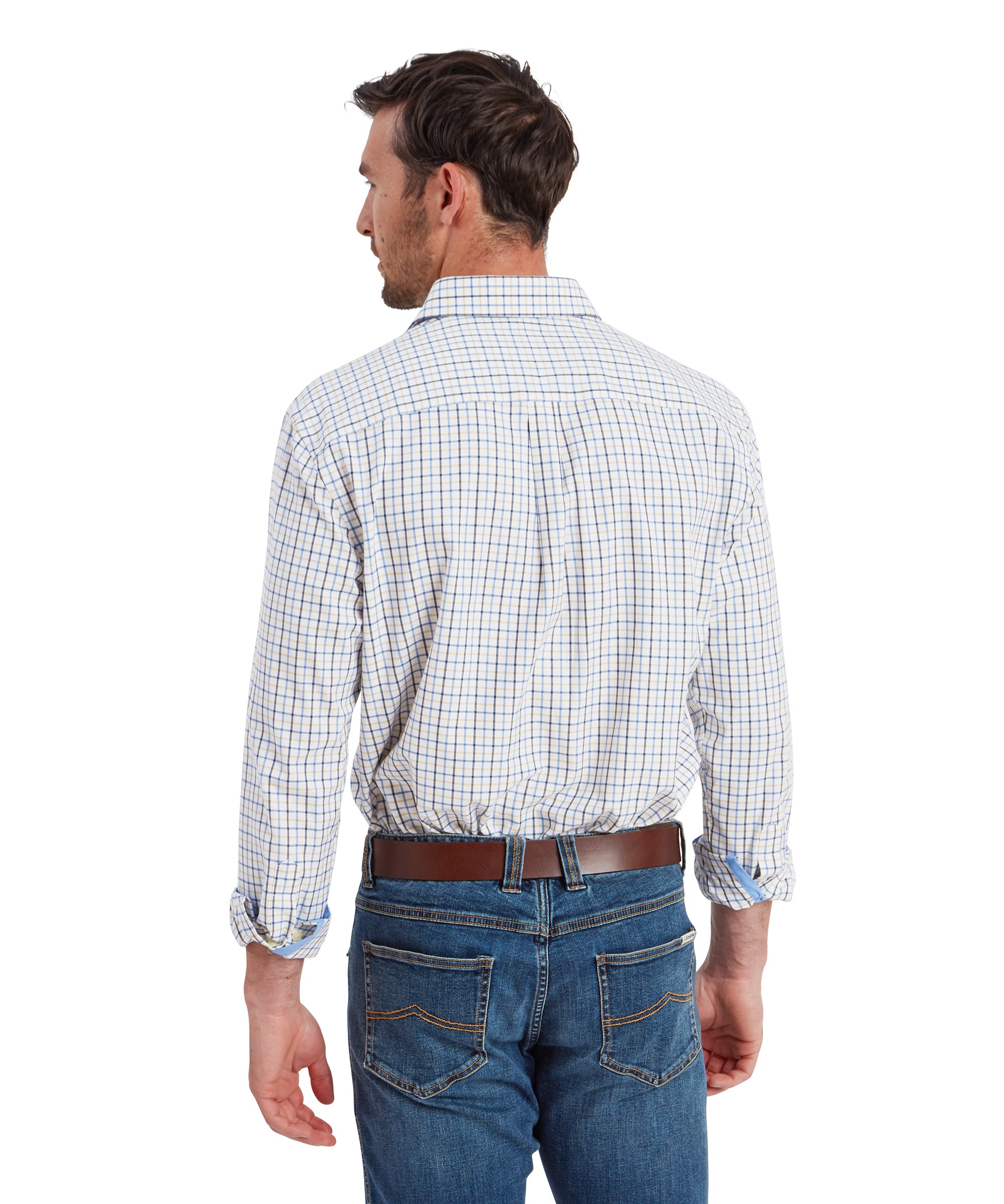 A rear view of the man wearing the same outfit. The Schöffel Milton Tailored Shirt for Men in Blue is neatly tucked into his blue jeans, and the brown leather belt is visible. The back of the shirt shows a clean, classic fit with pleats below the shoulder for added comfort and movement.