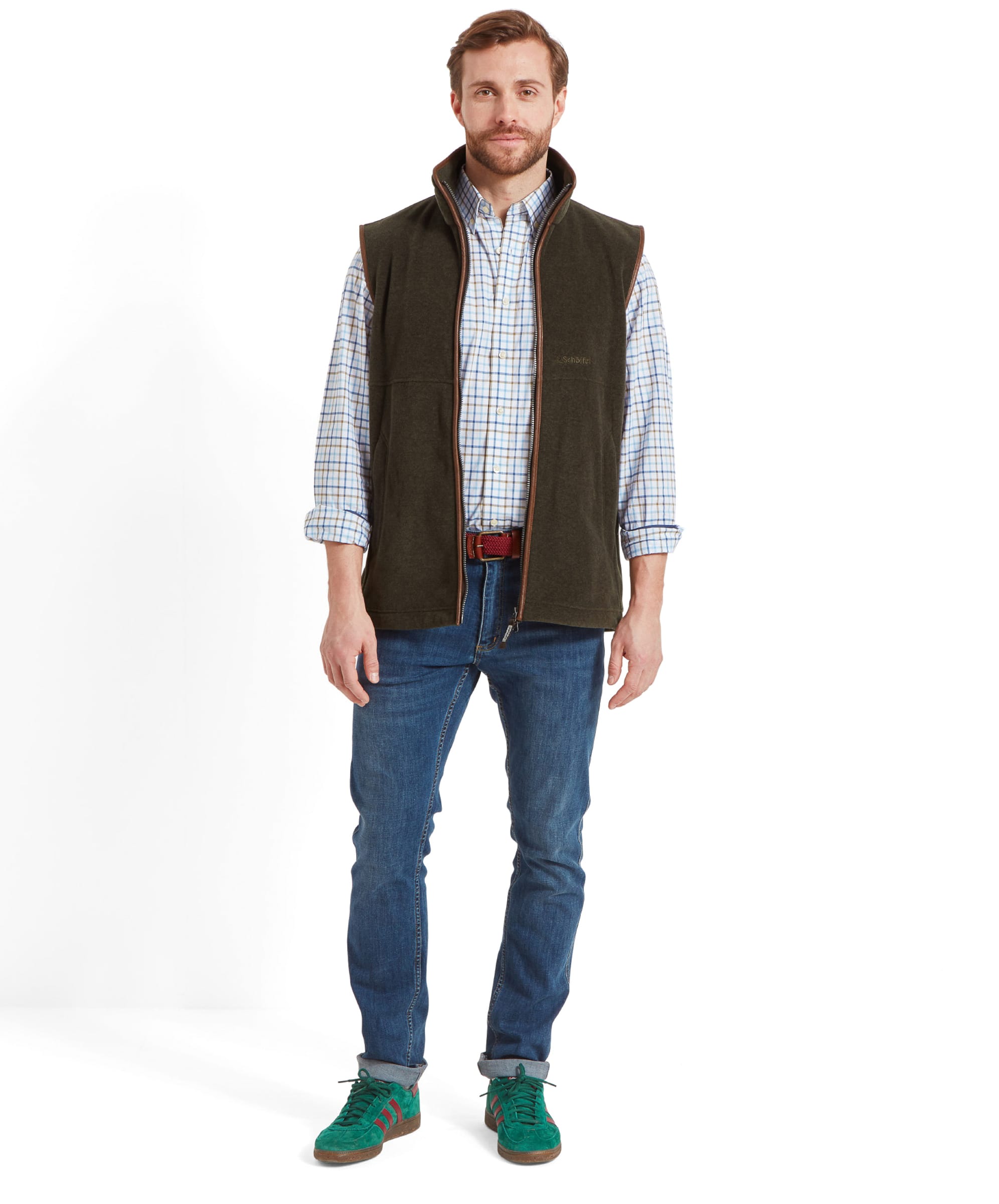 Full-body view of a man wearing the Schöffel Oakham Fleece Gilet for Men in Olive Green, paired with a checkered shirt and jeans, showcasing the overall fit and style.