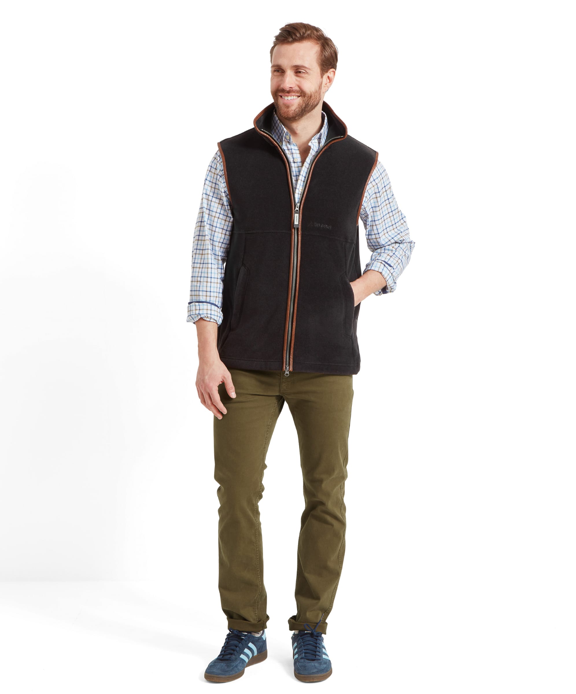 Model with hands in pockets, smiling, showing a casual stance wearing the Schöffel Oakham Fleece Gilet for Men in Grey.