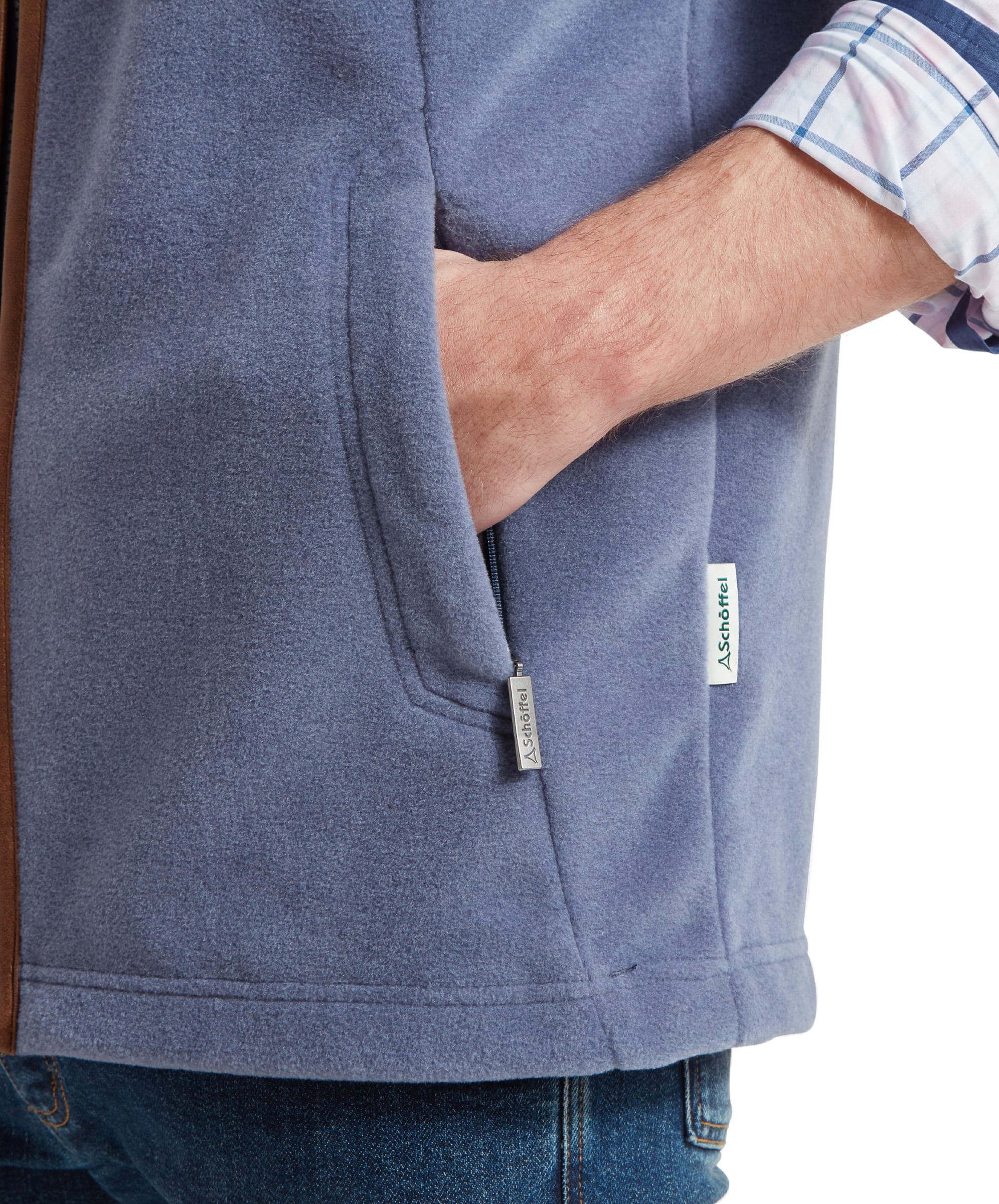 Close-up of the front side pocket on the Schöffel Oakham Fleece Gilet for Men in Light Blue highlighting the branded logo side seam tag and then metal branded zip pull on the pocket.